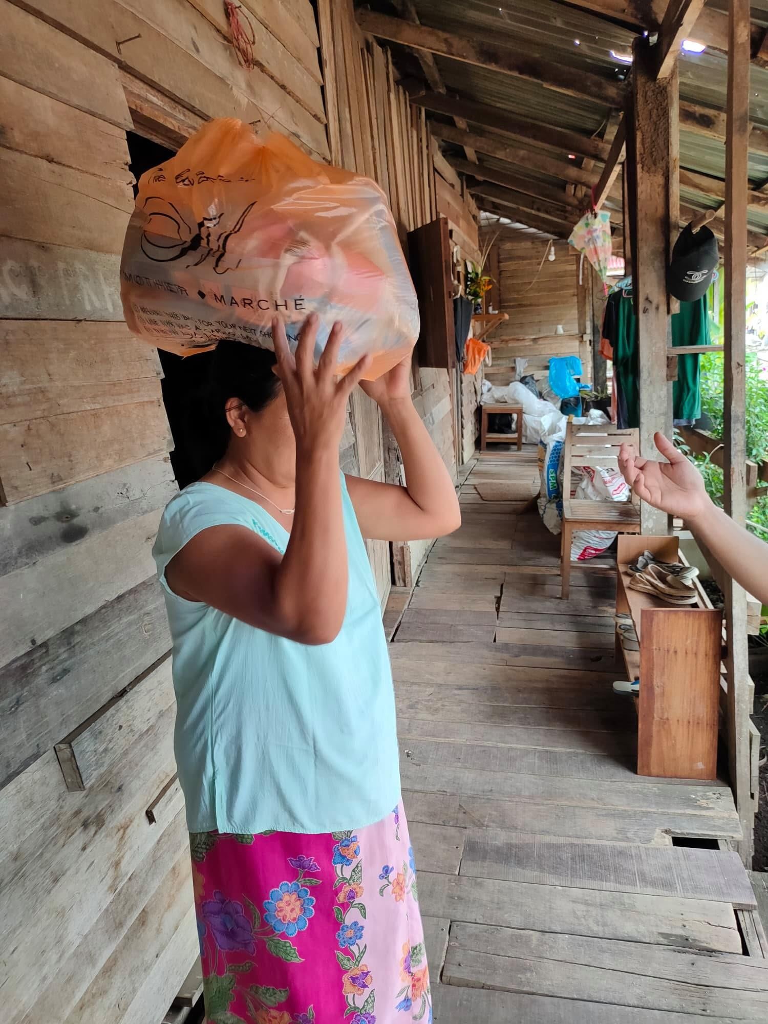 A woman holds food that has been delivered to her. Image courtesy of Hmine. Thailand, 2020.