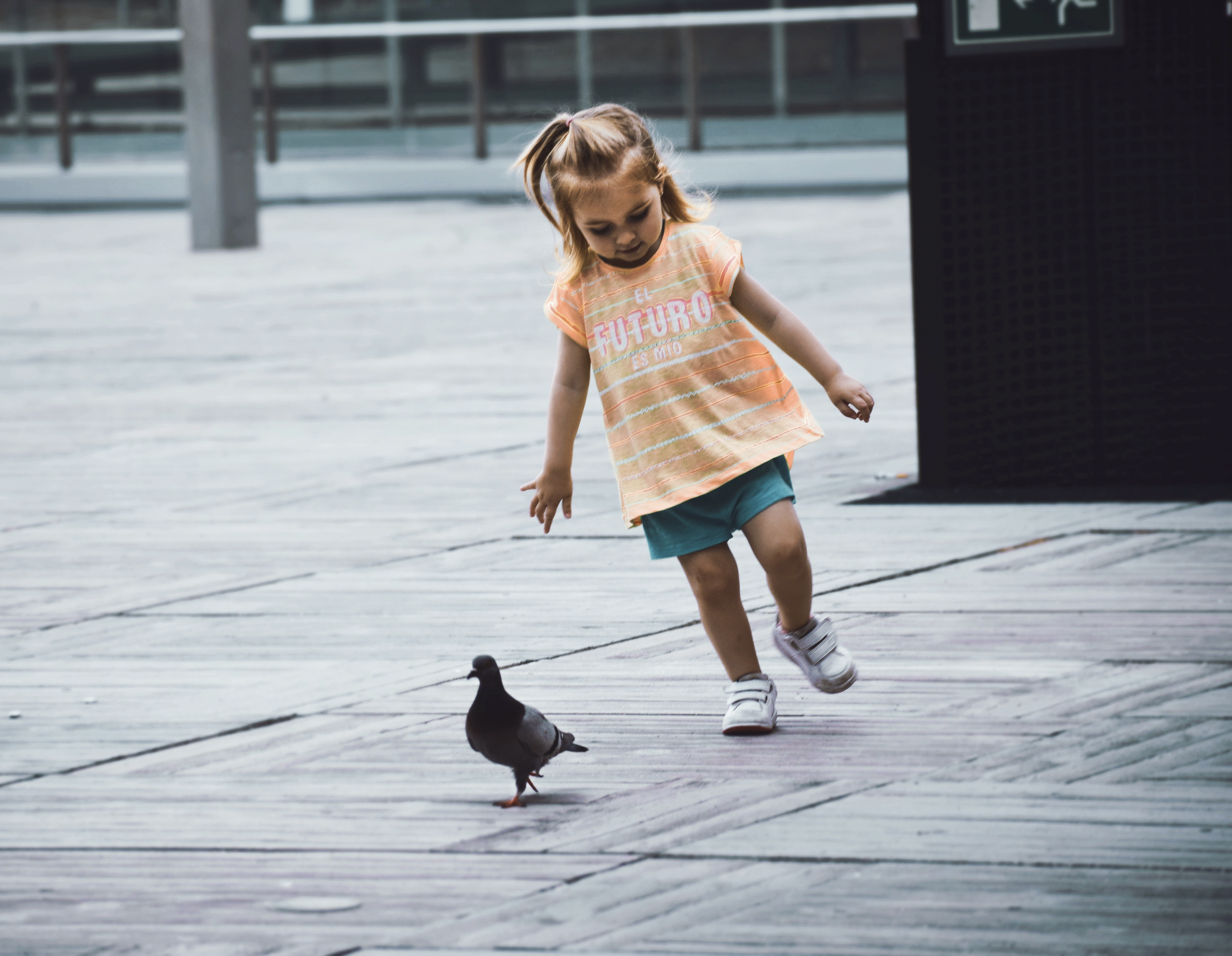 An image of a young girl chasing a pigeon.
"While building a wall may be a priority to some in America, others can still seek and find the rising future of this world on another coast...Spain." Image and text by Michelle Vasquez. Spain, 2017.