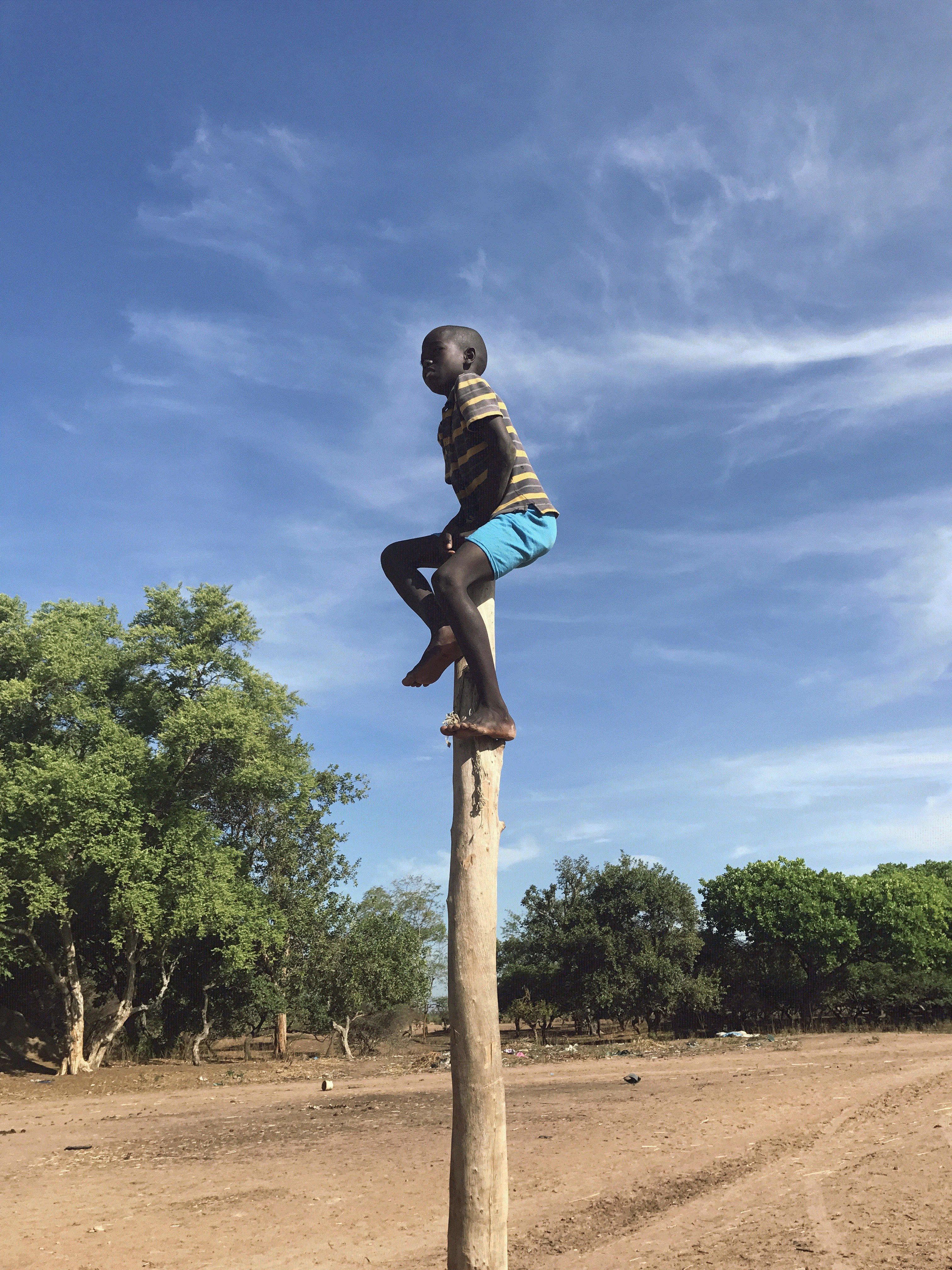 A child sits on top of a tall pole.

"To me this picture represents the hope of a bright and better future for the Senegalese kids. Upon visiting NdjiaNdjia, a village in Senegal, I couldn't help but notice that most kids were uneducated because they barely had enough schools to accommodate all of them and in addition to that at a certain grade level the kids would have to drop out because there are no advanced school grades. Nevertheless this picture shows high aiming and being satisfied when you reach the top." Image and text by Perpetua Nkem. Senegal, 2017.