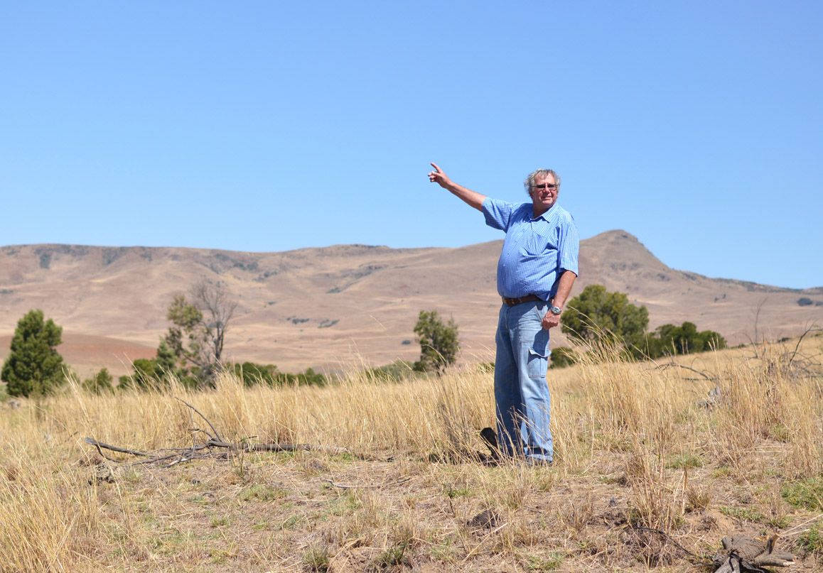 Farmer and chairman of the Mabola Protected Environment Oubaas Malan points out his farm from the proposed mine site. Because the mine would tunnel under a legally protected environment, it requires the written approval of the ministers of both the Department of Mineral Resources and the Department of Environmental Affairs. Image by Mark Olalde. South Africa, 2016. 