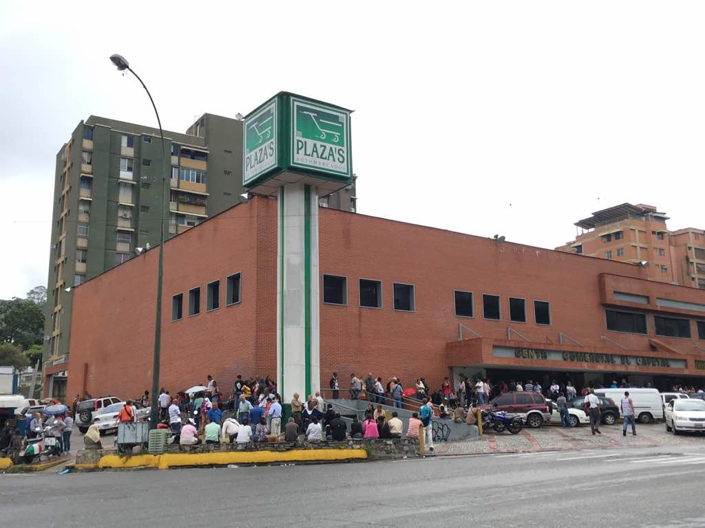 Long line of people wait to enter Plaza Supermarket . Image by María González. Venezuela, 2017.