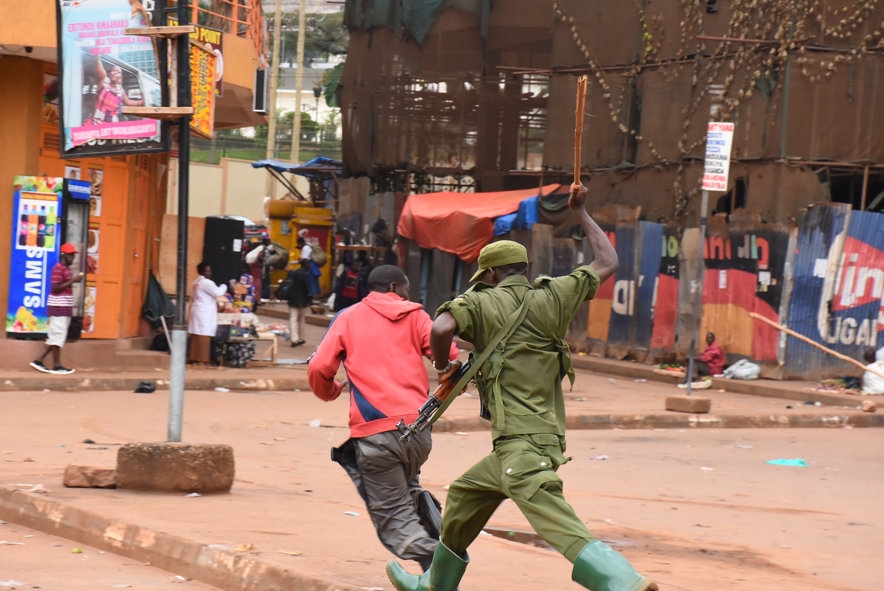 An LDU soldier beats a person during implementation of coronavirus restrictions in Kampala in March. Image by Alex Esagala. Uganda, 2020.