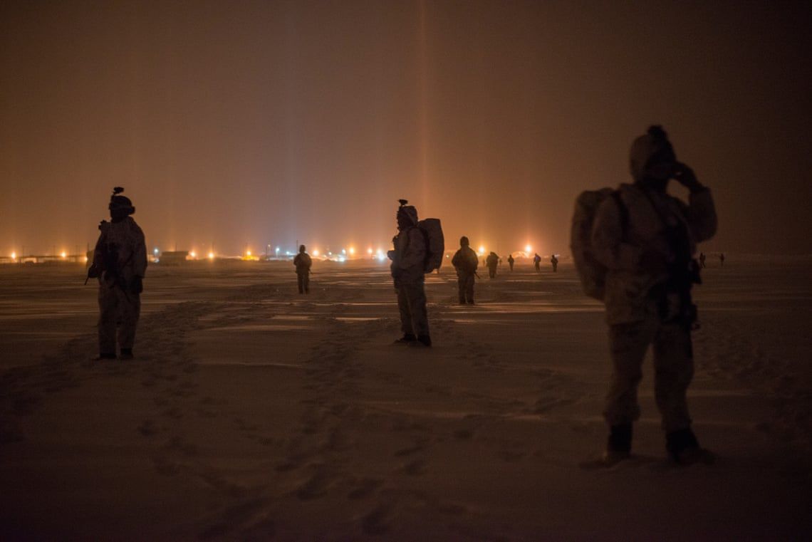 U.S. marines and army special forces walking toward a long range radar station operated by Norad in Utqiaġvik, Alaska. These troops are taking part in the U.S. military’s annual Arctic Edge exercise. Image by Louie Palu / Zuma Press. United States, 2020.
