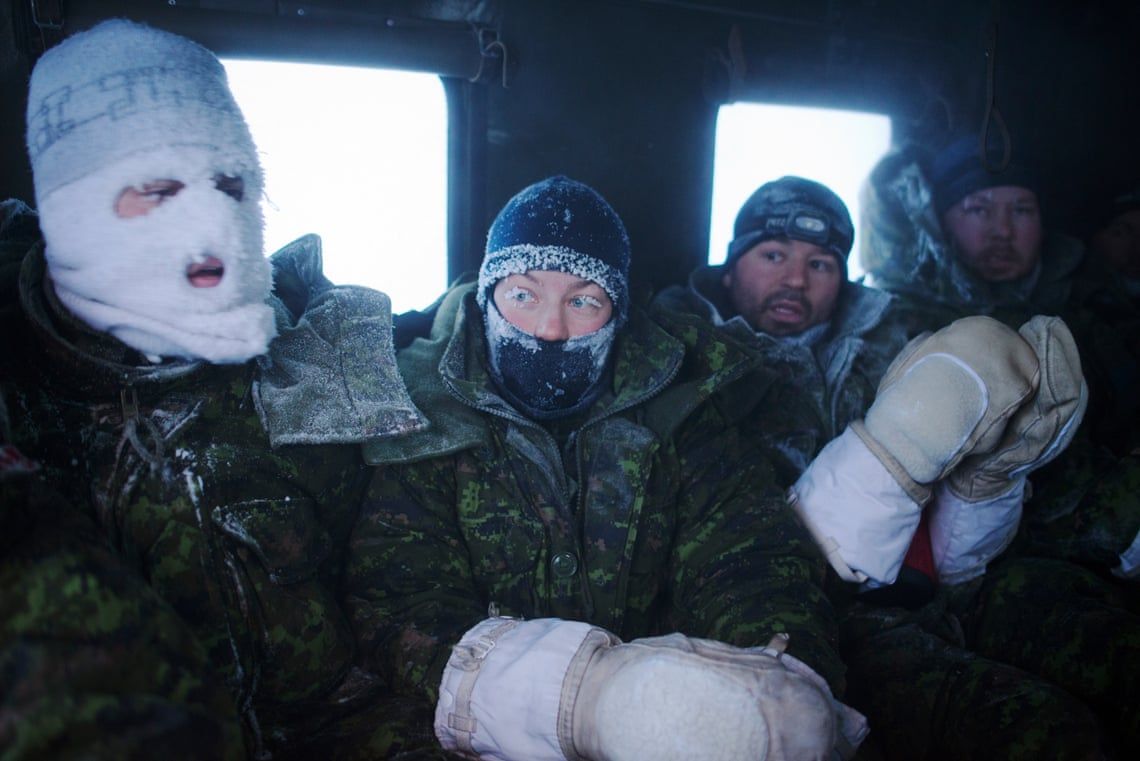 Canadian pilots and air crew seen after a week of Arctic survival training for military personnel from Canada, the UK and France at the Canadian Forces Crystal City training facility near Resolute Bay in Nunavut, Canada. These military personnel are in a tracked ground vehicle taking them back to heated facilities after a week of living outdoors in makeshift shelters at temperatures below -50C. Image by Louie Palu / Zuma Press. Canada, undated. 