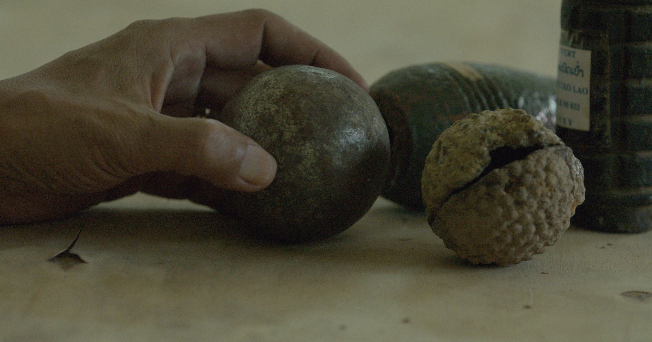 The UXO Lao Province coordinator explains how similar petanque balls and cluster bombs are. Image by Erin McGoff. Laos, 2017.