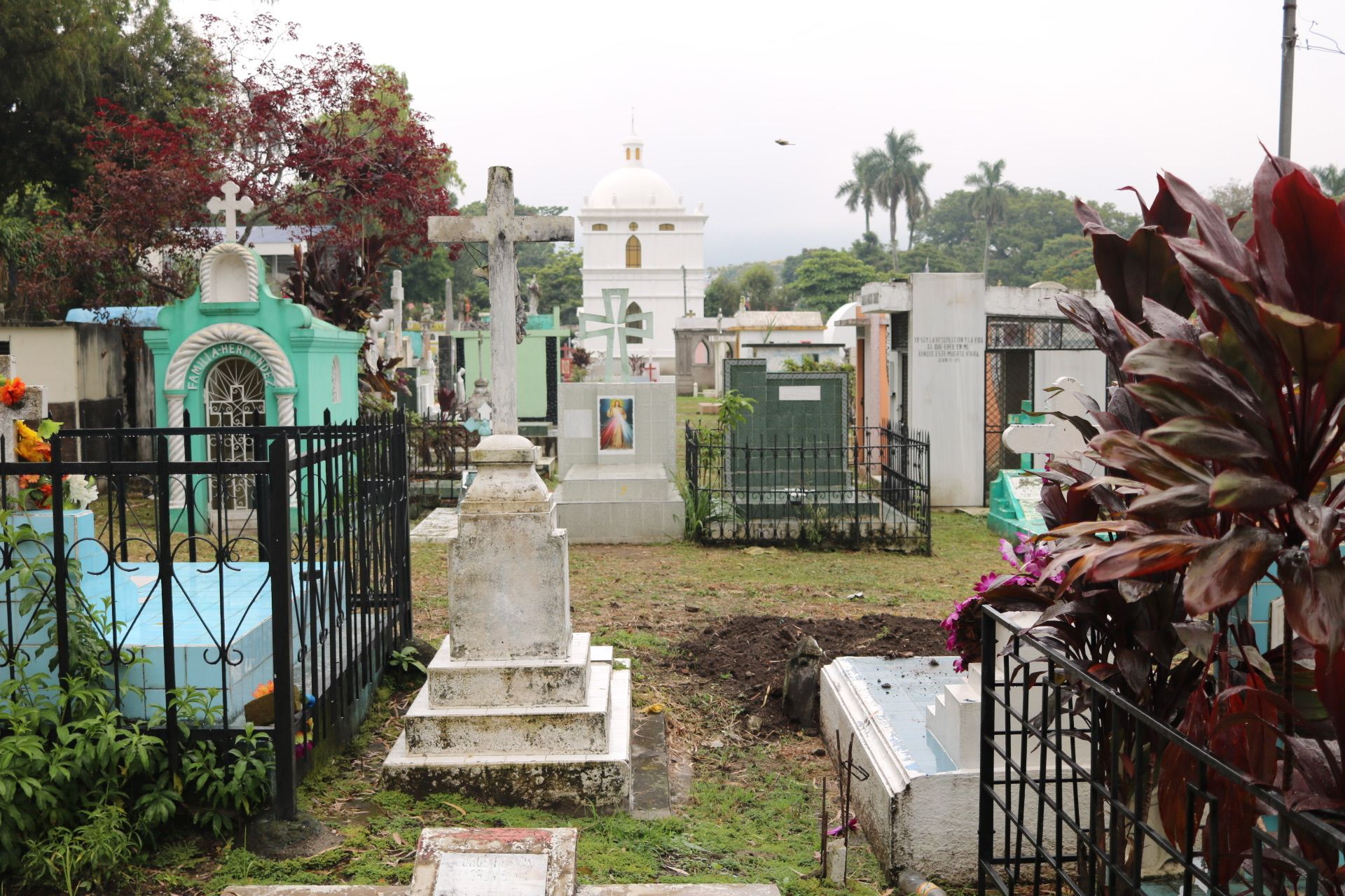 Muddy pathways weave in and out of gravestones at the Cementerio Municipal Santa Tecla. Image by Lauryn Claassen. El Salvador, 2017.