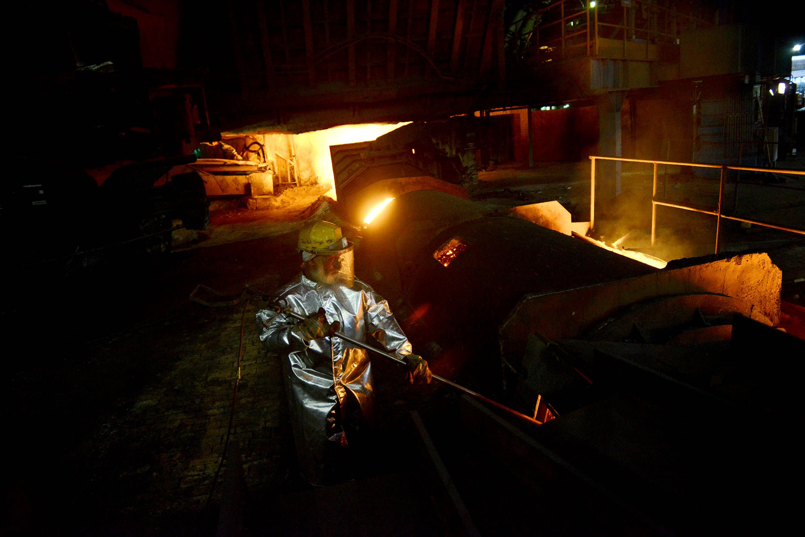 A Tata Steel worker checks the temperature of the one of the plant's seven blast furnaces during an afternoon. Image by Michael Henninger. India, 2016.