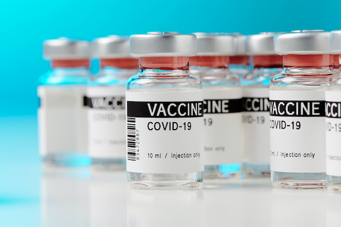 Ampoules with a COVID-19 vaccine on a laboratory bench. Image by M-Foto/Shutterstock. 2020.