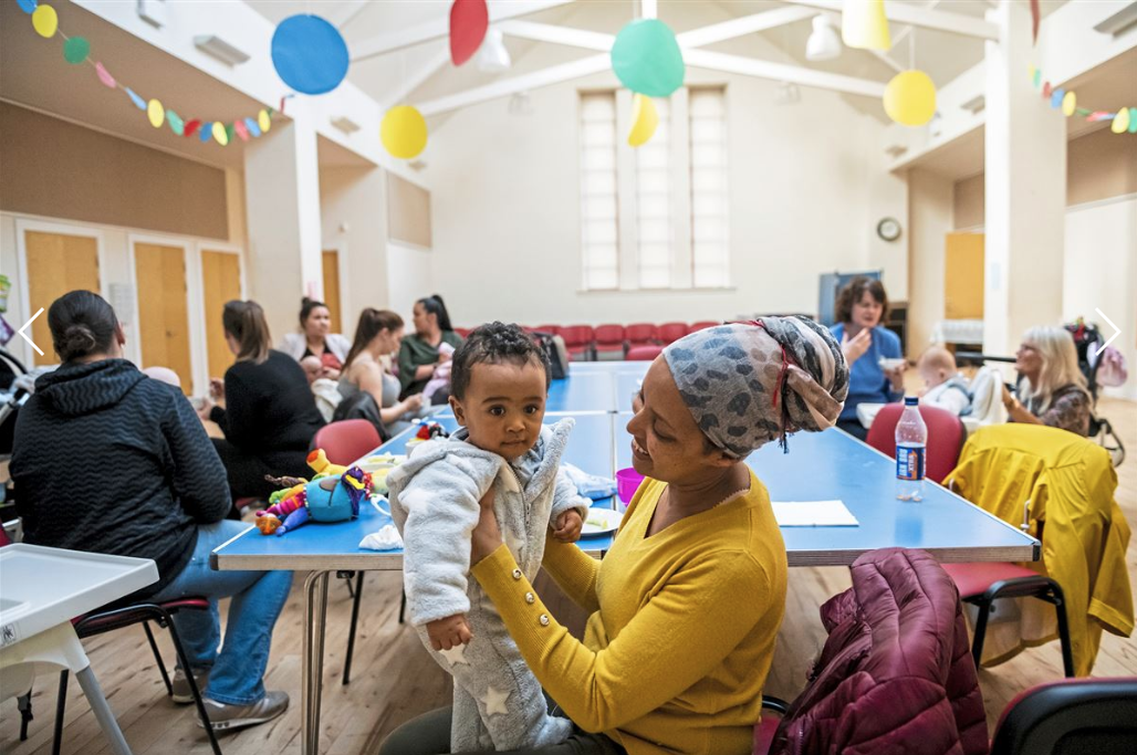Hanna Abrha holds her son, Eliad, 7 months, as they enjoy their time at Cafe Stork, Tuesday, Oct. 21, 2019, at Parkhead Congregational Church in Glasgow, Scotland. Cafe Stork is a free networking lunch for families in the disadvantaged East End who are expecting or new parents. Image by Michael M. Santiago. United Kingdom, 2019.