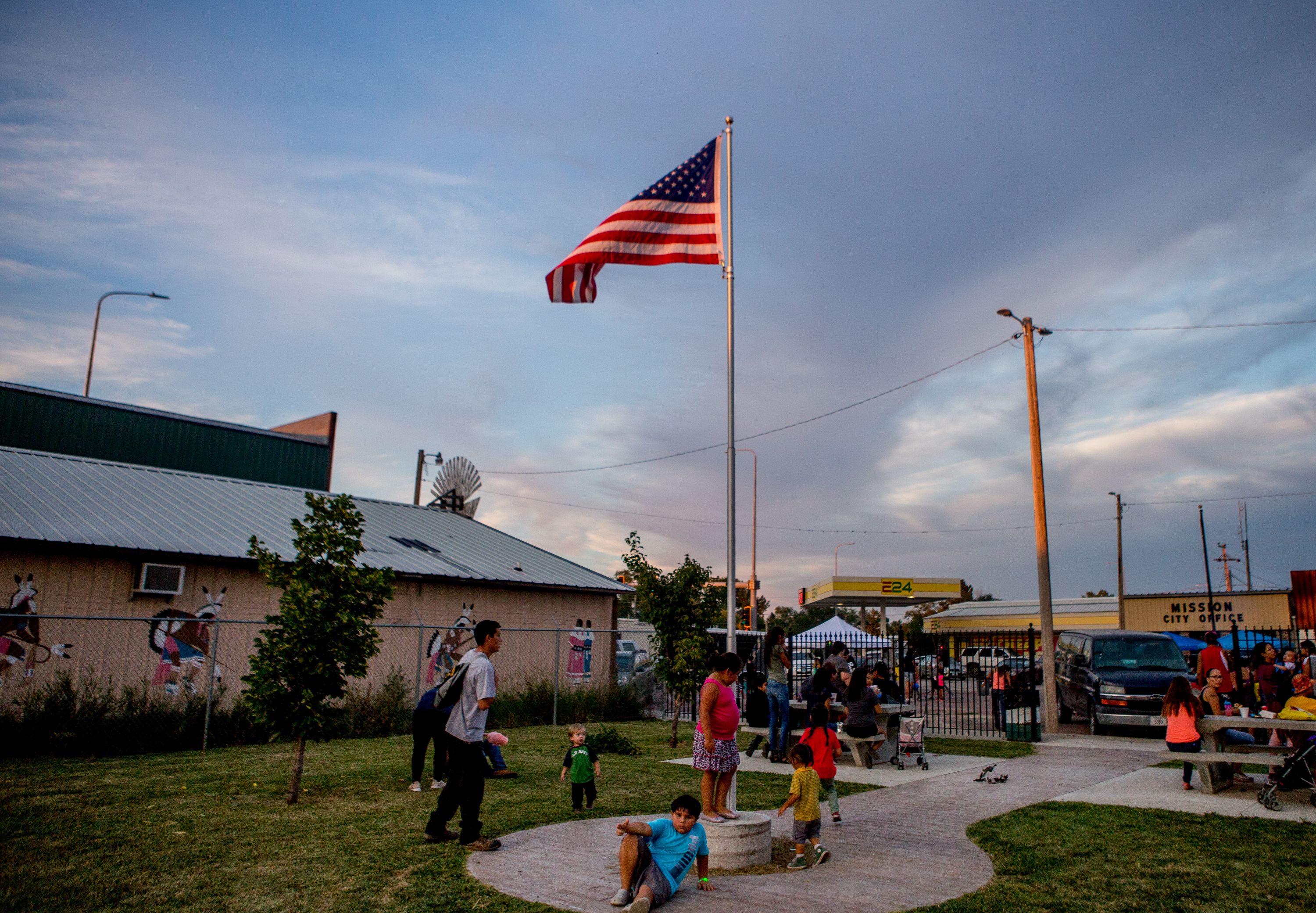 Mission residents and children relax on September 1, 2018, during the first annual Sicangu Youth Program "Back-to-School" block party in Mission, South Dakota. Image by Brian Munoz. South Dakota, 2018.