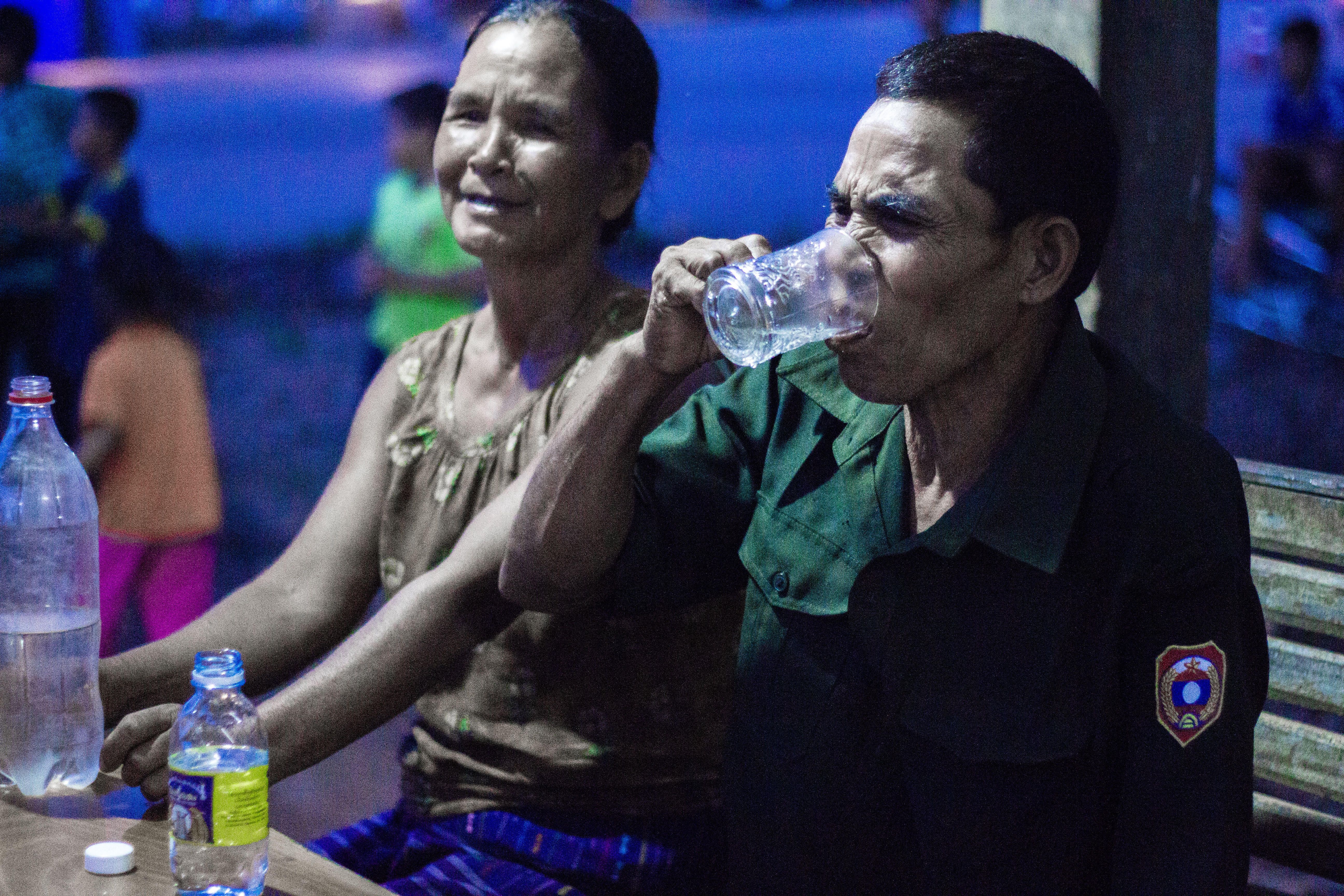 Mr. and Mrs. Vounta take turns drinking Lao Lao while celebrating their visitors. Image by Erin McGoff. Laos, 2017. Image by Erin McGoff. Laos, 2017.