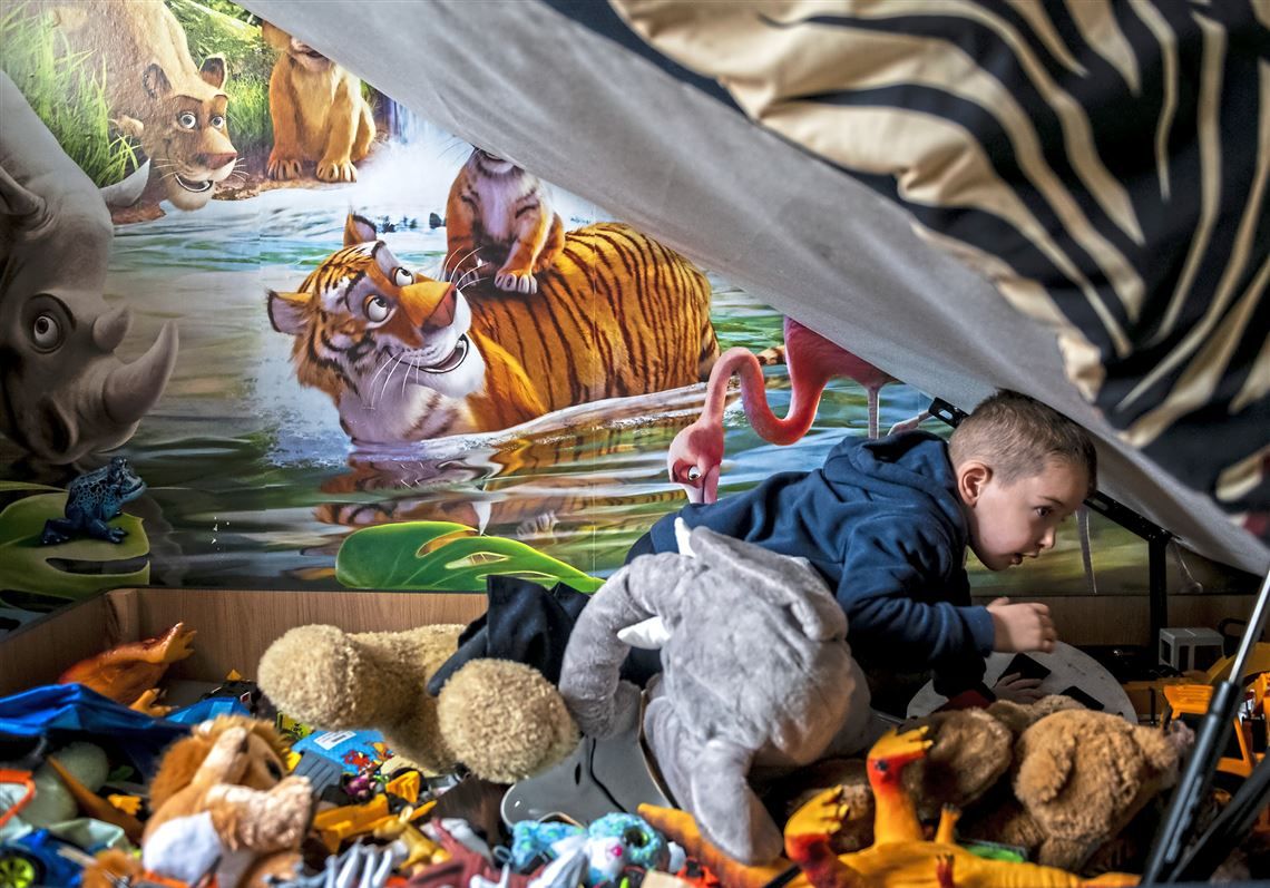 Spartacus Summers, 5, of Faifley, digs through his storage bed to look for a toy. Spartacus' bed was donated to the family two months ago by a local charity. Image by Michael M. Santiago. Scotland, 2019.