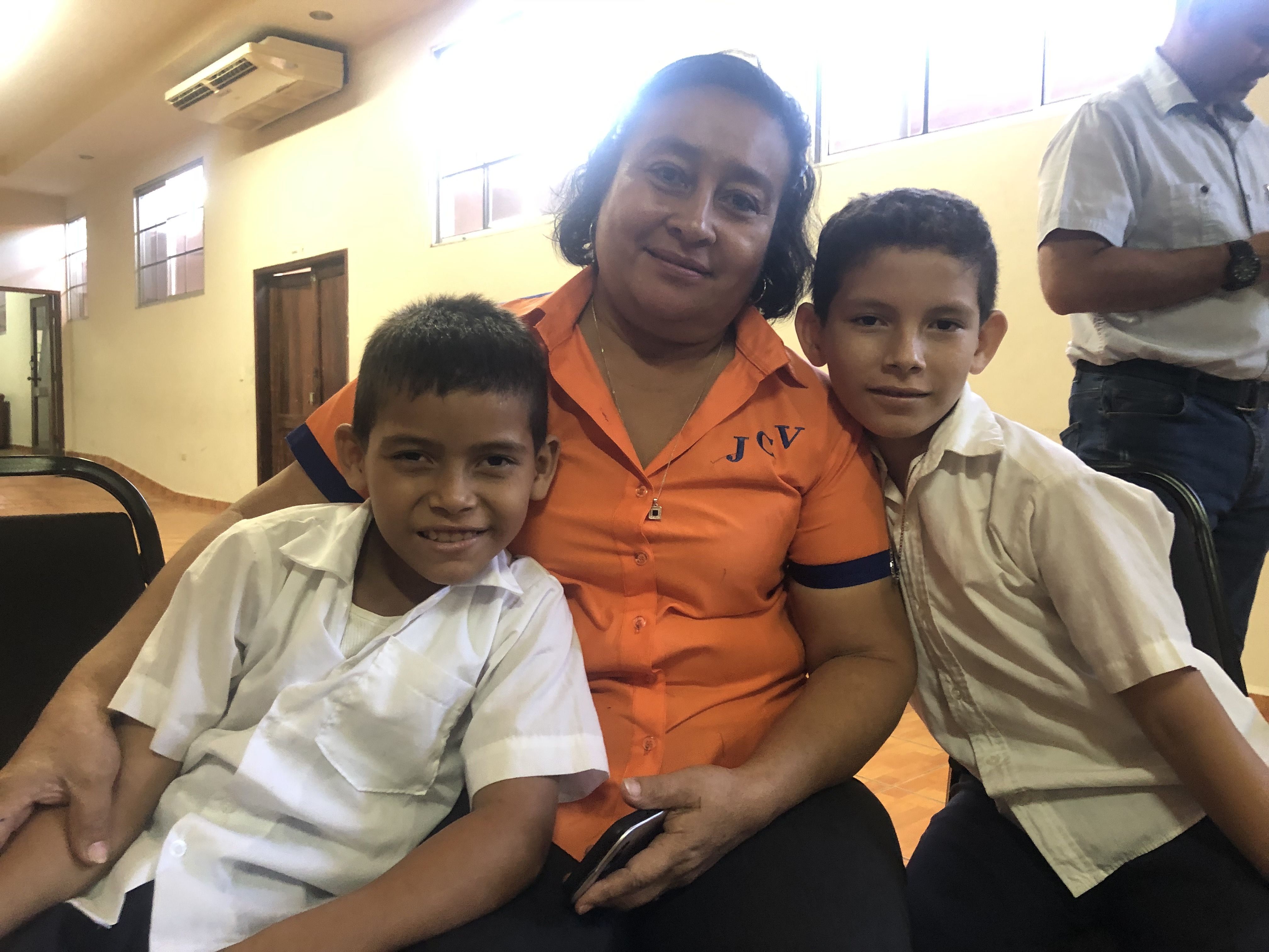 Berkling Yaiso (left) is 9. His brother Germán is 10. Here, at a community meeting in Potrerillos, they pose with one of their teachers. Image by Jaime Joyce/TIME for Kids. Honduras, 2019.
