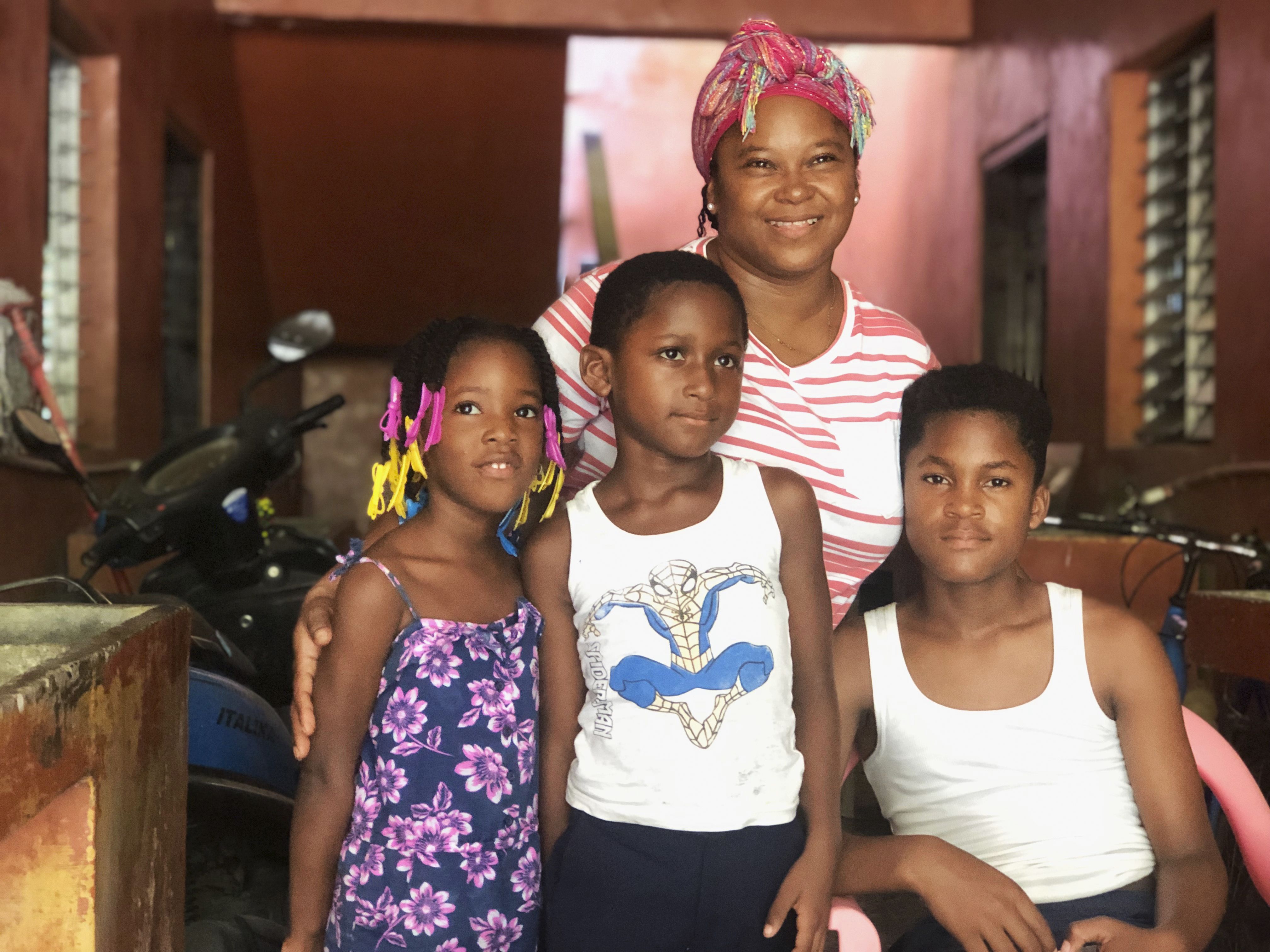 Akon Spencer (right) poses with a cousin; his brother, Laer; and his mom, Selma Blanco, in La Lima. Image by Jaime Joyce. Honduras, 2019.