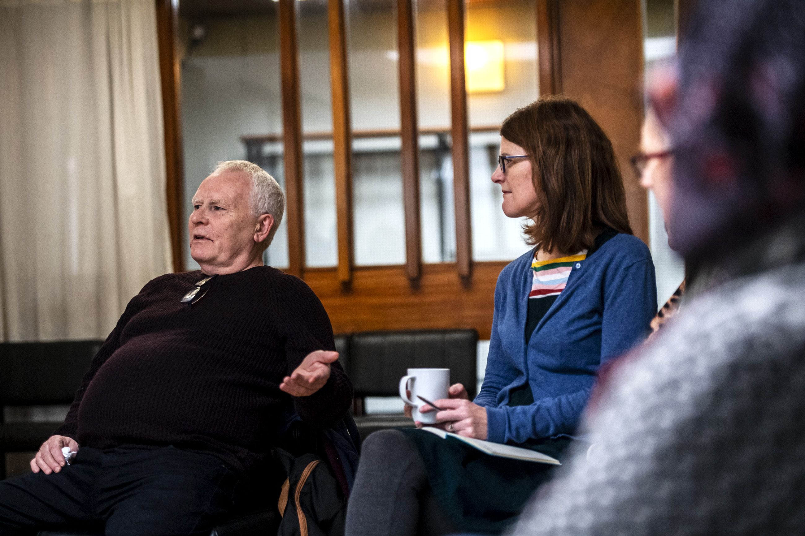 Pat Martin, of Possilpark, a neighborhood of Glasgow, left, speaks during the monthly Poverty Truth Community meeting as Elaine Downie, coordinator of the Poverty Truth Community, listens. Image by Michael Santiago. United Kingdom, 2019.