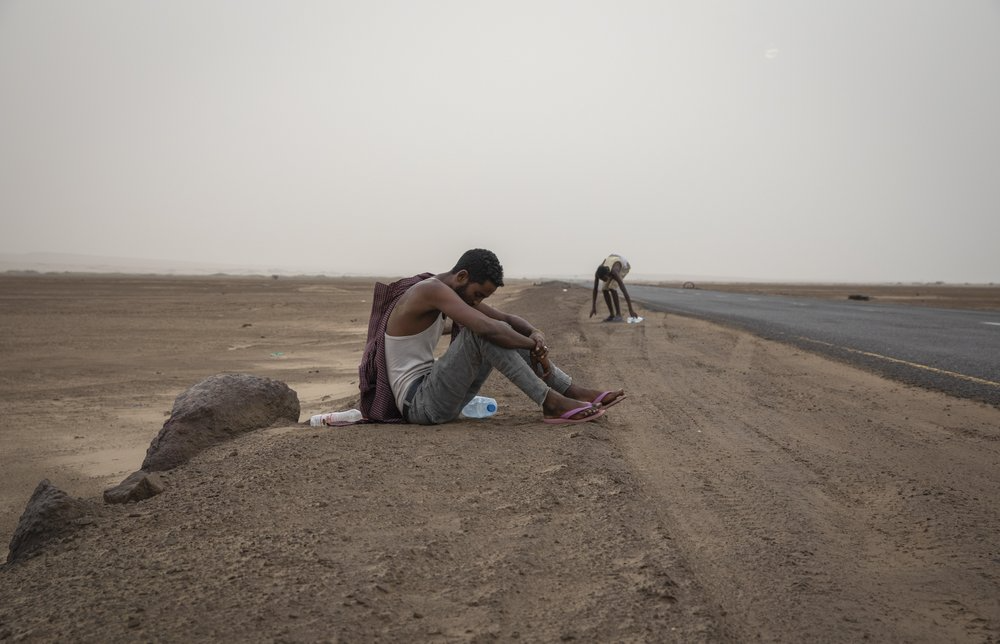 Ethiopian migrants rest on the side of a highway in Lahj, Yemen, early in the morning, as they make their way to Aden. Image by Nariman El-Mofty. Yemen, 2019.