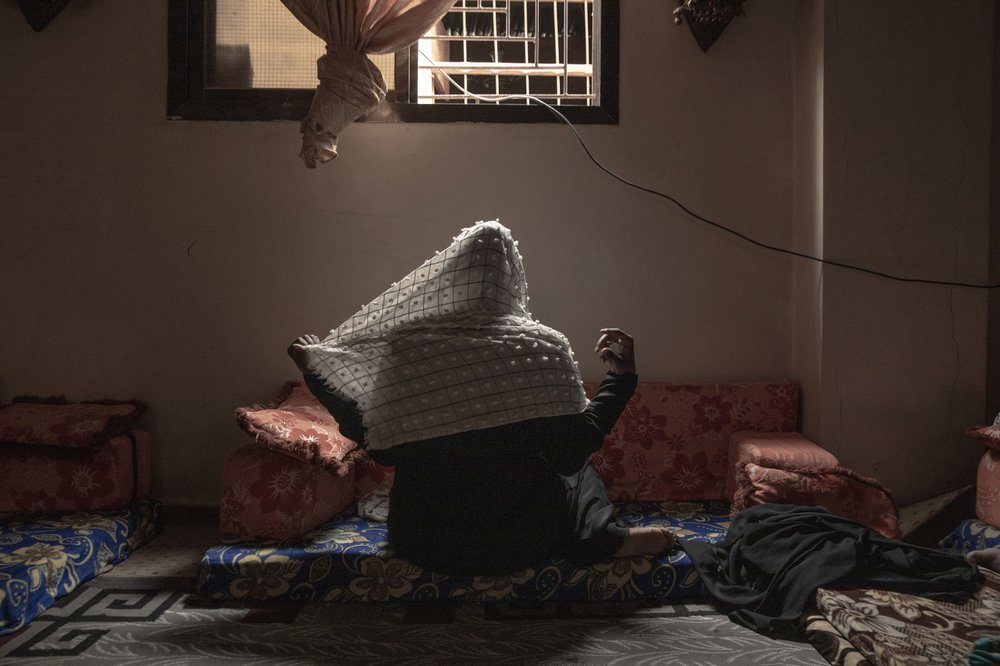 20-year-old Ethiopian migrant Zahra, a rape victim, adjusts her veil for a photograph, in Basateen, a district of Aden, Yemen. She was imprisoned for a month in a tin-roofed hut, broiling and hungry, ordered to call home each day to beseech her family to wire $2,000. She said she did not have family to ask for money and pleaded for her freedom. Instead, her captors raped her. Image by Nariman El-Mofty. Yemen, 2019.