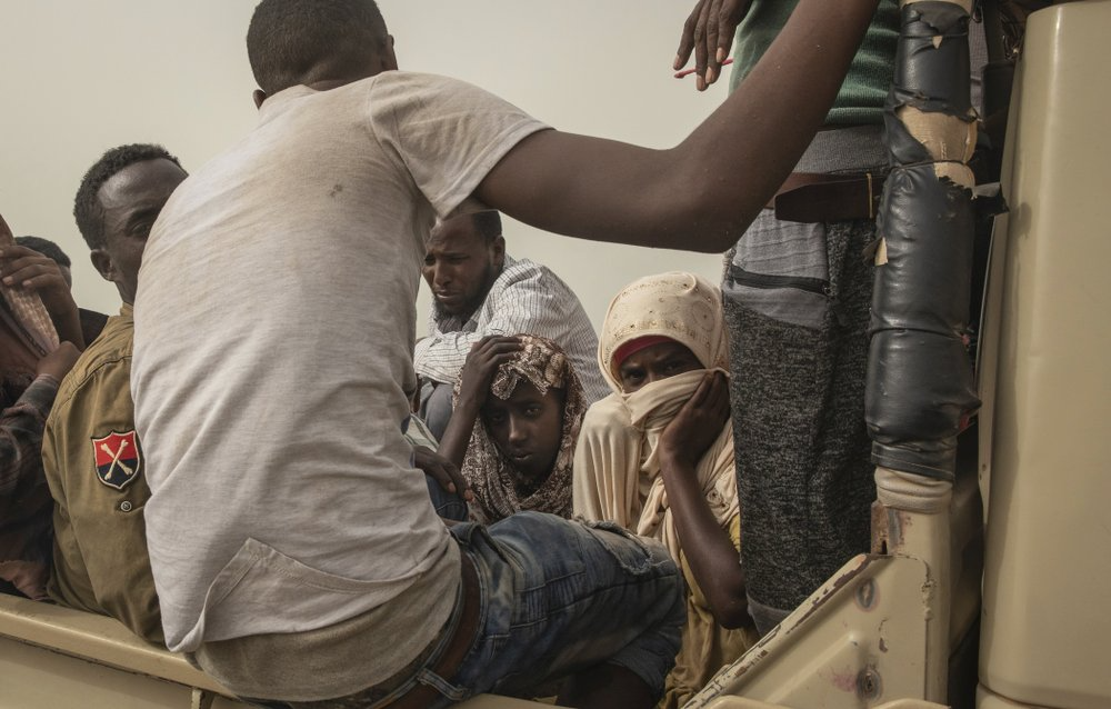 Ethiopian migrants sit in the back of a pickup truck to be taken to desert compounds known in Arabic as "hosh," in Ras al-Ara, Lahj, Yemen. The AP spoke to more than two dozen Ethiopians who survived torture at Ras al-Ara. Nearly all of them reported witnessing deaths, and one man died of starvation hours after the AP saw him. Image by Nariman El-Mofty. Yemen, 2019.