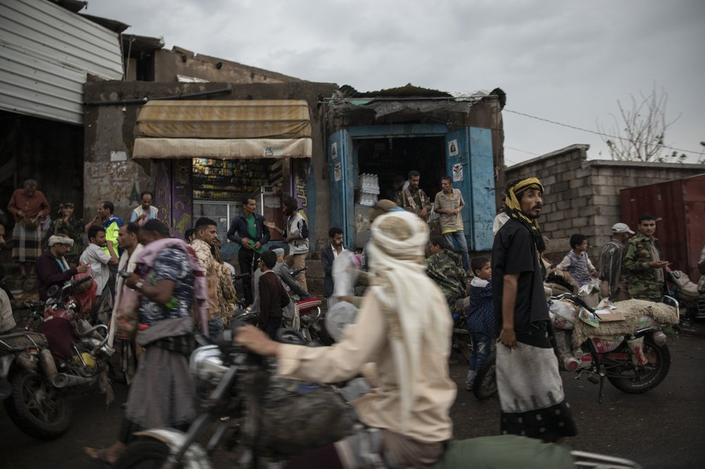 People gather at a market in Dhale province, in Yemen. The area is one of the stops where Ethiopian migrants take shelter to continue their journey to Saudi Arabia, and an active frontline between militiamen backed by the Saudi-led coalition and Houthi rebels only a few hundred meters away. Image by Nariman El-Mofty. Yemen, 2019.