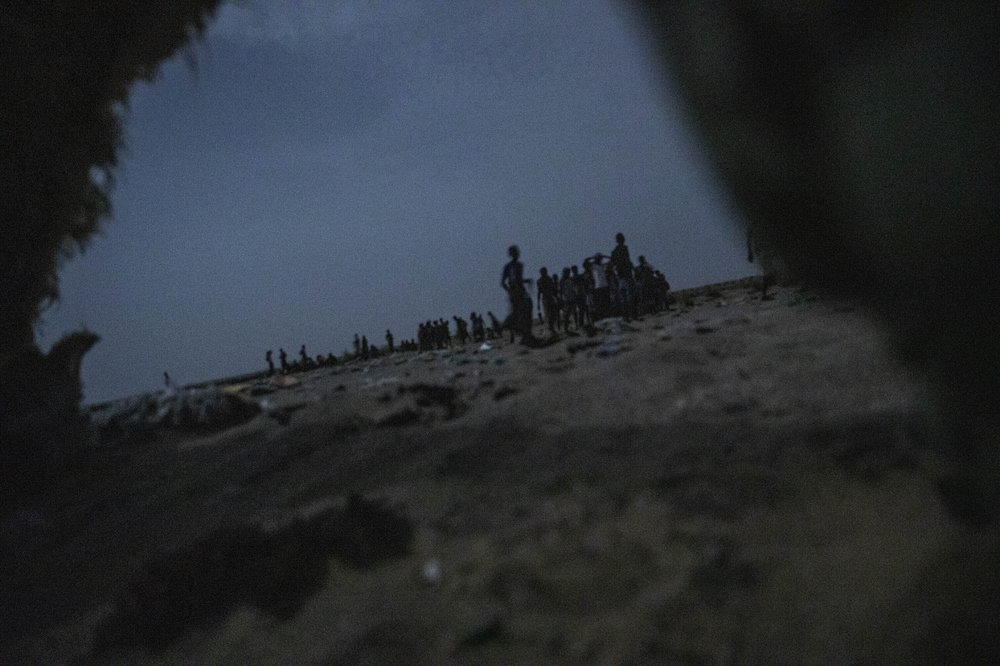 Ethiopian migrants stand in line to board a boat on the uninhabited coast outside the town of Obock, Djibouti, the shore closest to Yemen. Image by Nariman El-Mofty. Djibouti, 2019.