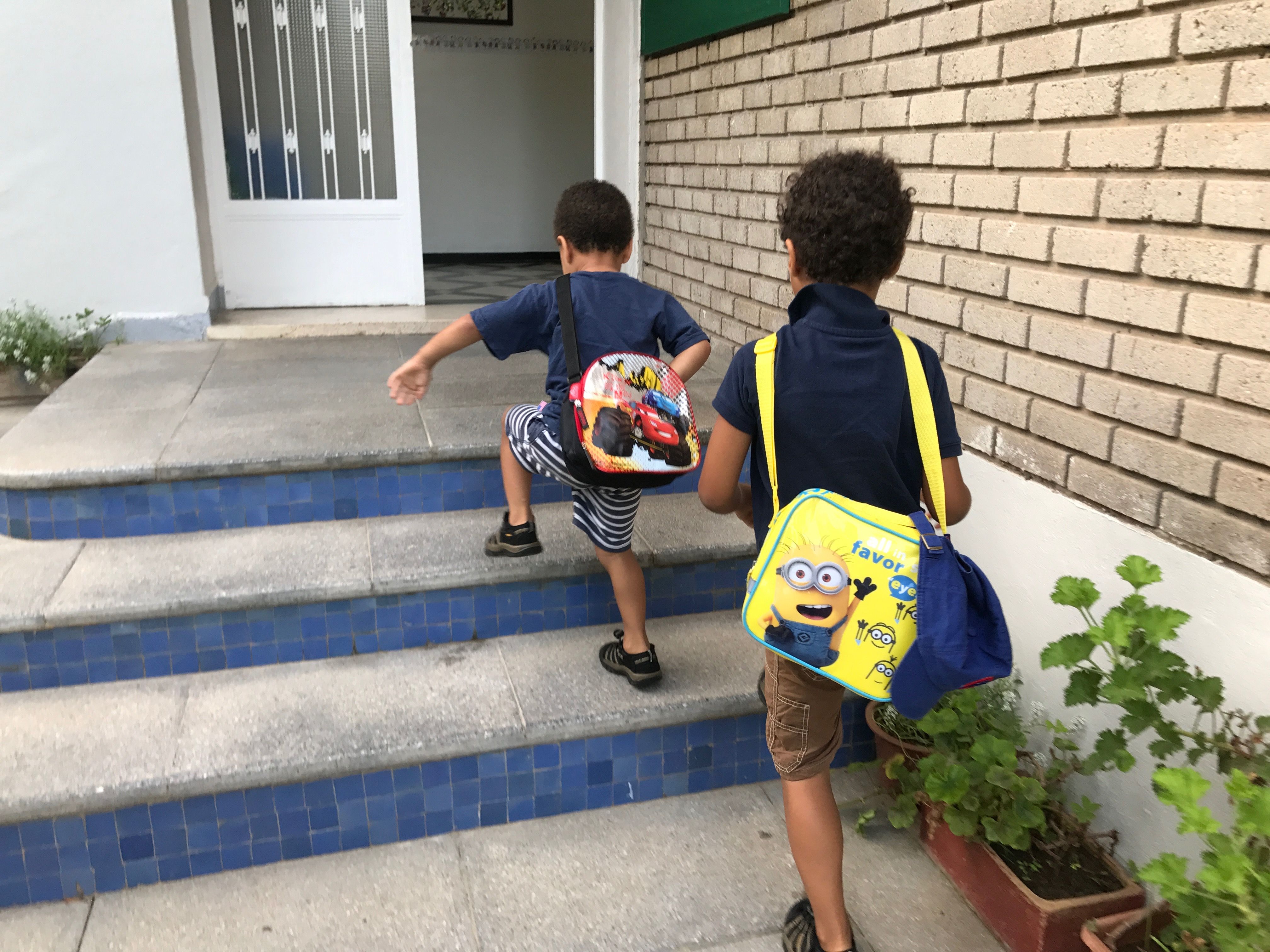The author's sons, ages 5 and 3, walk up the stairs at their private French school in Morocco. The boys are autistic. Image by Jackie Spinner. Morocco, 2017.
