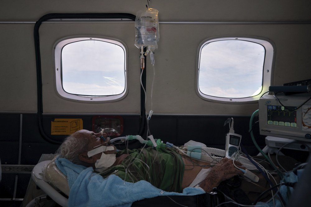 COVID-19 patient Sildomar Castelo Branco, 89, is treated onboard an aircraft as he is transferred from Santo Antônio do Iça to a hospital in Manaus in Brazil's Amazon state, Tuesday, May 19, 2020. Image by AP Photo/Felipe Dana. Brazil, 2020.