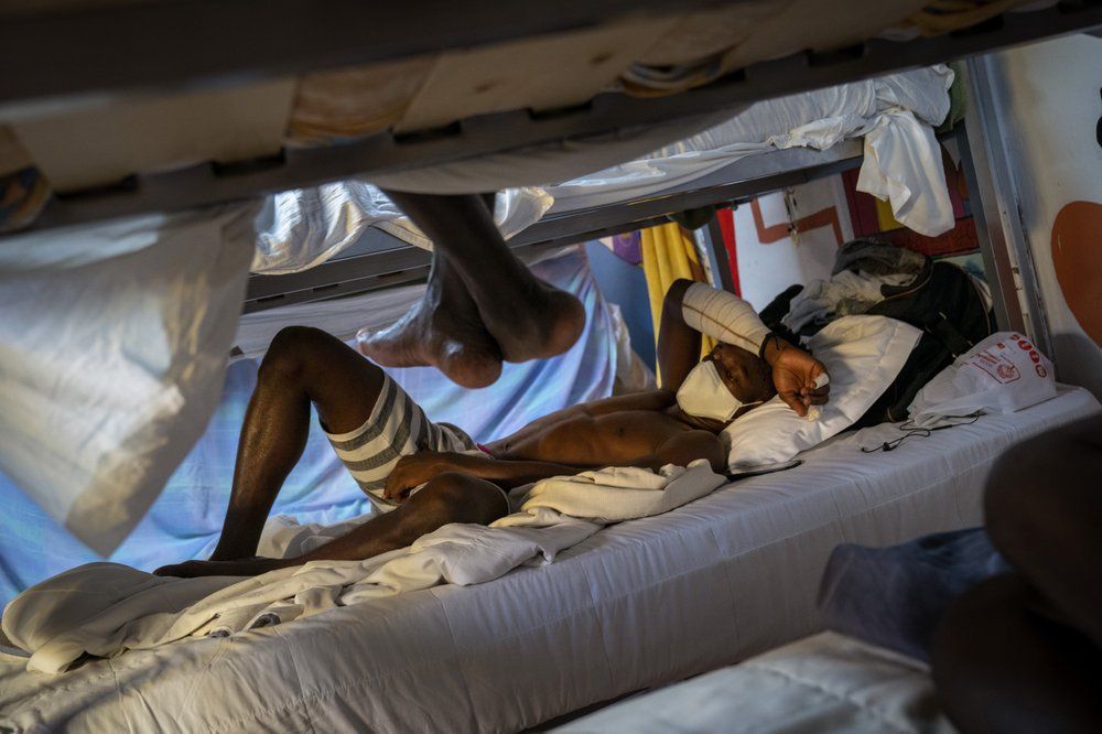 Hady Baye, 31, rests in a bunk bed at the Modern Christian Mission Church in Fuerteventura, one of the Canary Islands, Spain, on Saturday, Aug. 22, 2020. Image by Emilio Morenatti/AP Photo. Spain, 2020.