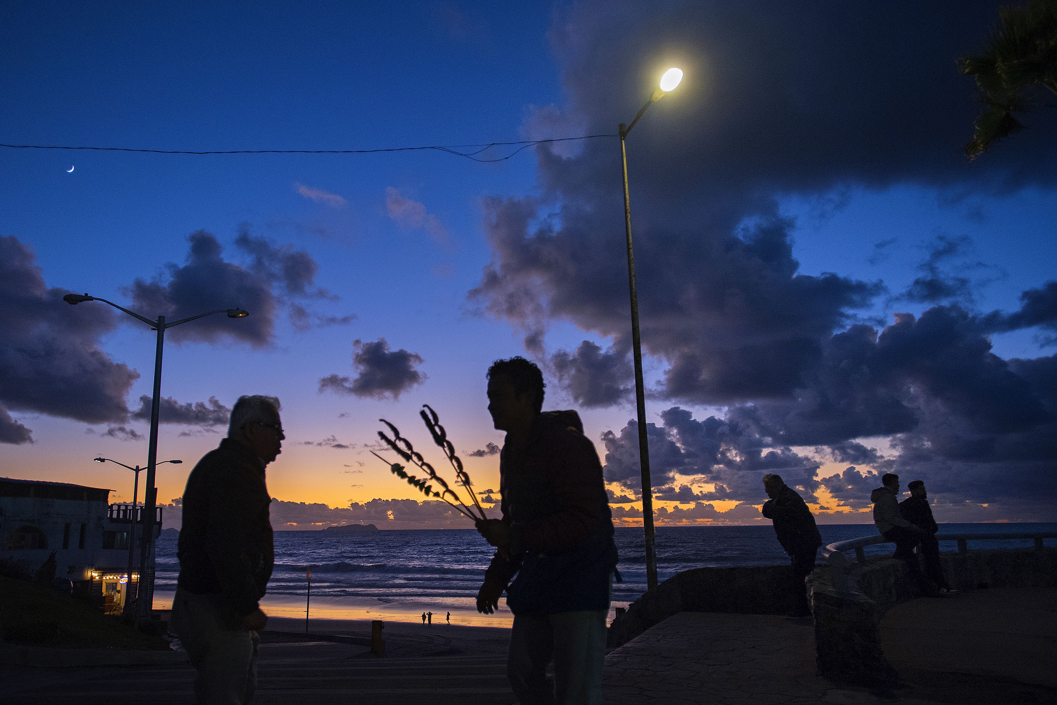 Vibrant color from the sunset provides a dramatic scene for locals and visitors at Playas de Tijuana on Nov. 29. Residents and tourists alike are drawn to the popular area for the beach, scenic views, seafood, restaurants and local bars. Image by Amanda Cowan. Mexico, 2019.