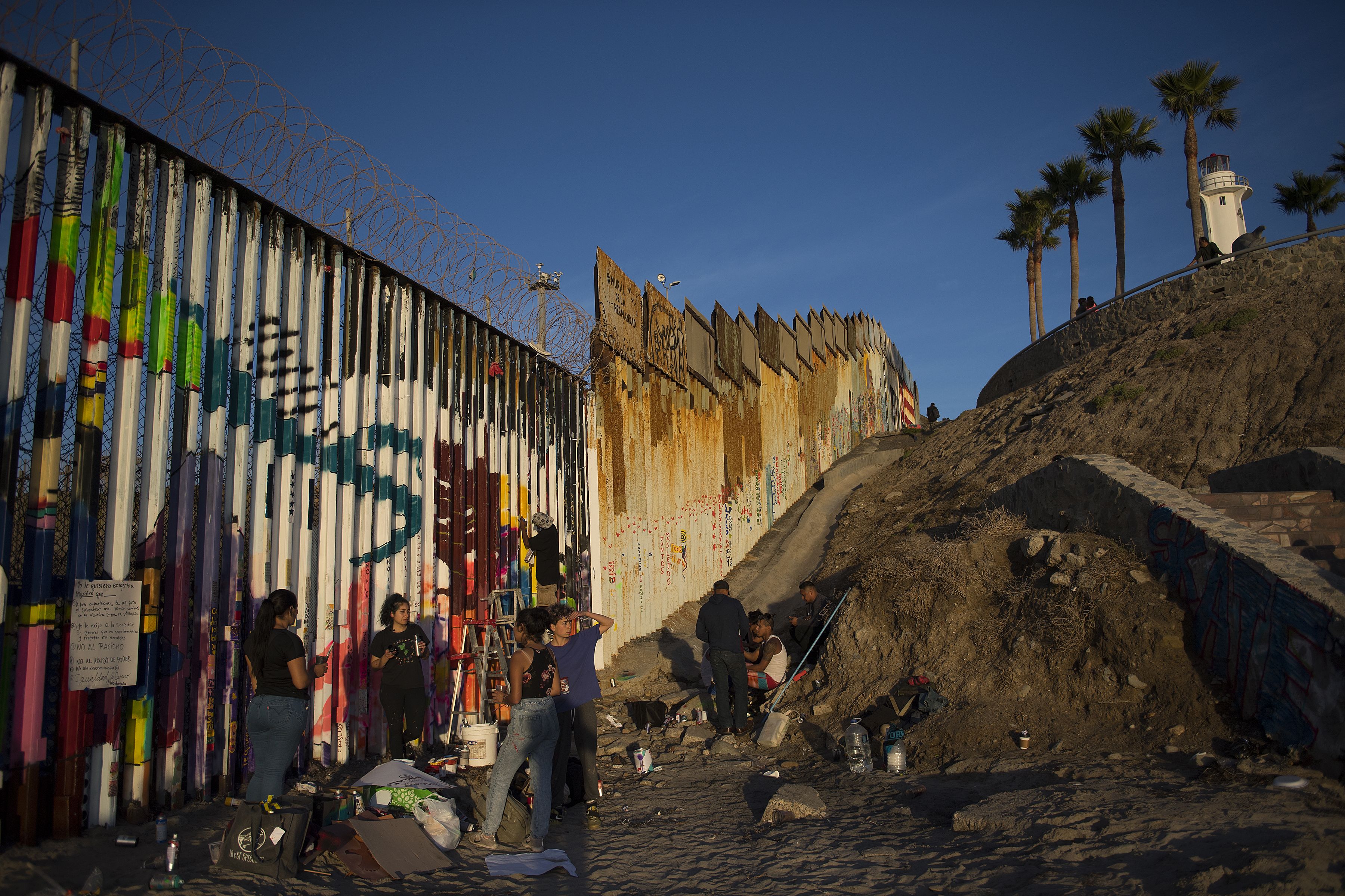 Artists add a personal touch to the border wall at Playas de Tijuana at sunset Dec. 1. Image by Amanda Cowan. Mexico, 2019.