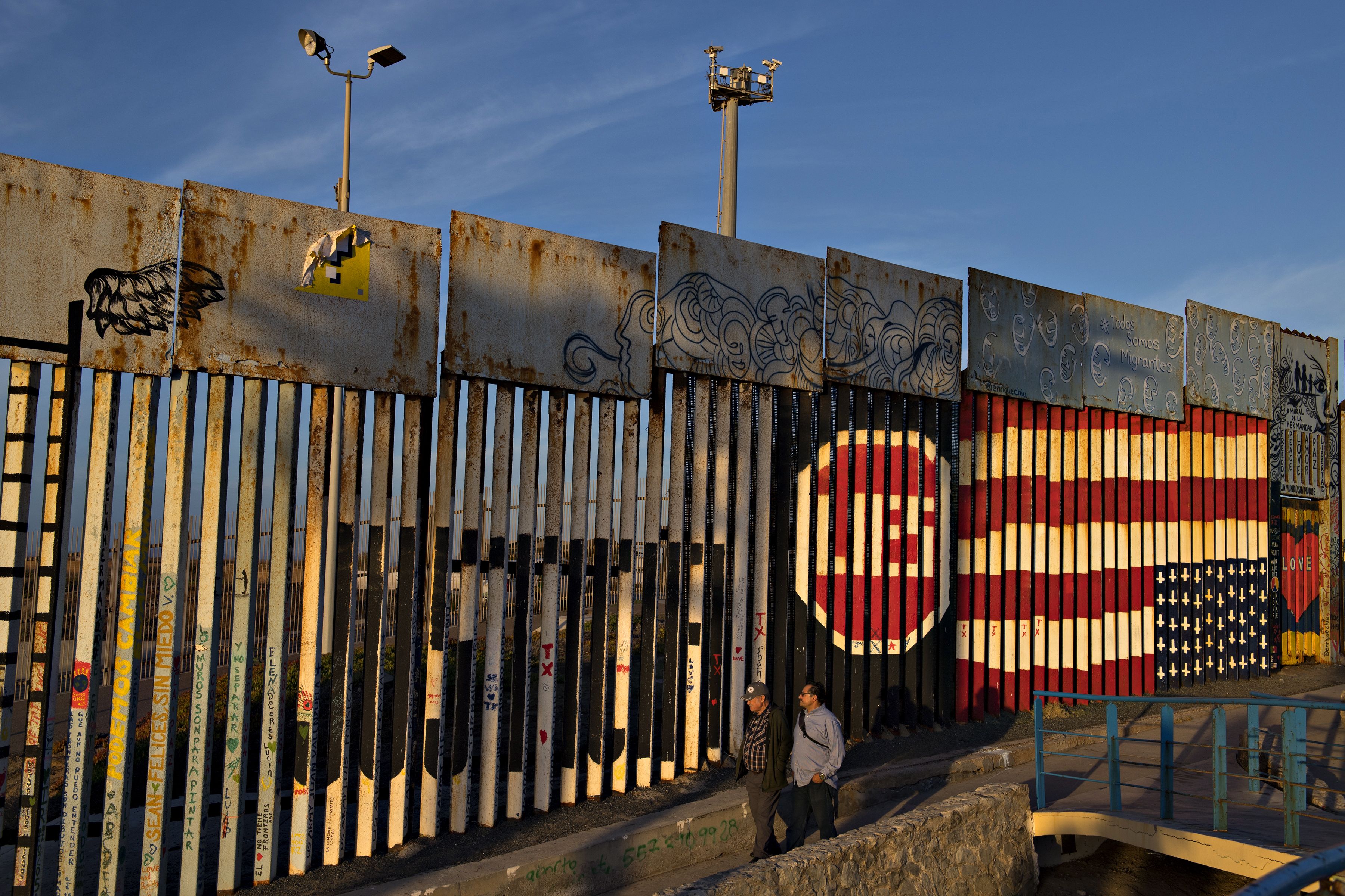 Visitors to Playas de Tijuana stop by the border wall at Friendship Park to look over artwork Dec. 1. Friendship Park is located along the United States-Mexico border in the San Diego-Tijuana region and is a half-acre in size. Image by Amanda Cowan. Mexico, 2019.