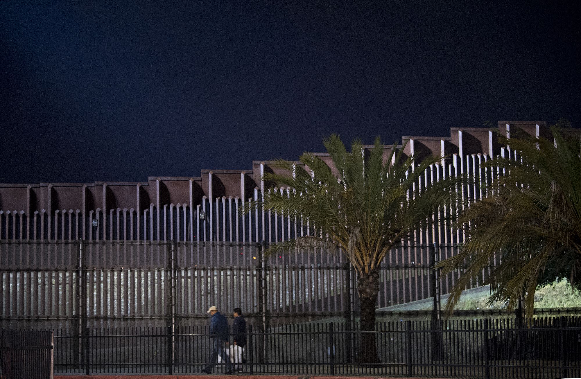 Pedestrians stroll near the border wall on foot from the United States side Nov. 27. Image by Amanda Cowan. United States, 2019.