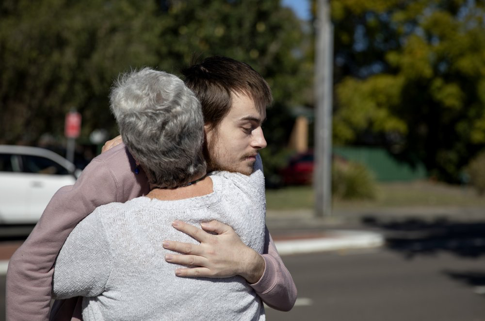 Sam Ware, 22, hugs his mother, Deb, after seeing her for the first time since his last overdose in Fountaindale, Central Coast, Australia, Friday, July 19, 2019. Image courtesy of David Goldman. Australia, 2019.