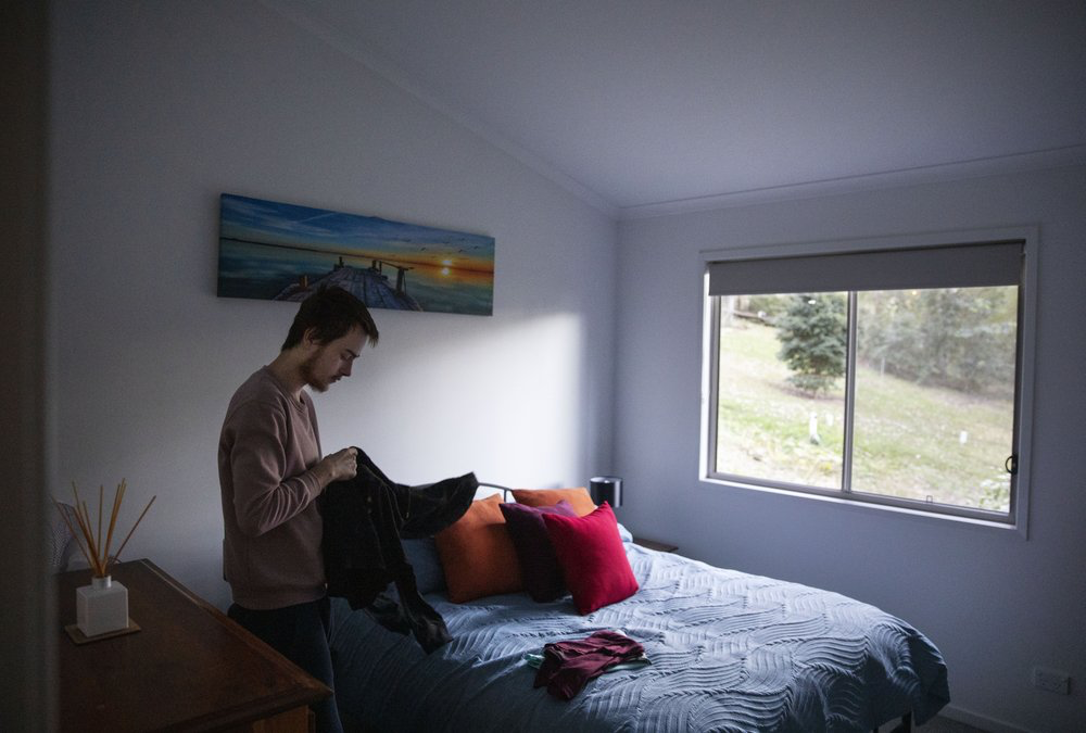 Sam Ware, 22, packs some clothes from his mother's home upon returning for the first time since overdosing there three weeks earlier, in Fountaindale, Central Coast, Australia, Friday, July 19, 2019. Image courtesy of David Goldman. Australia, 2019.
