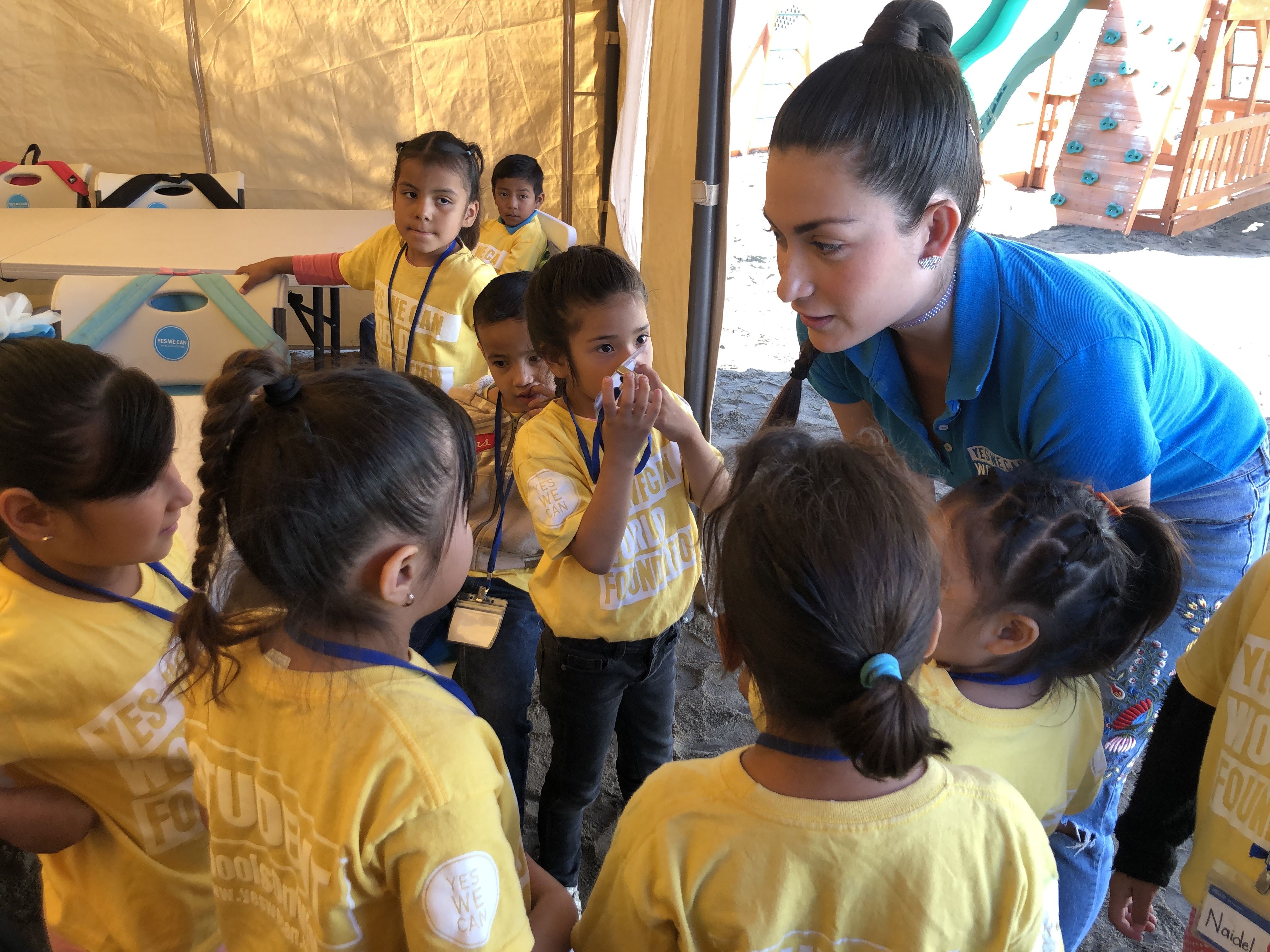 Estefanía Rebellón greets students at the Yes We Can World Foundation school in Tijuana, Mexico, on October 3. Image by Jaime Joyce. United States, 2019.