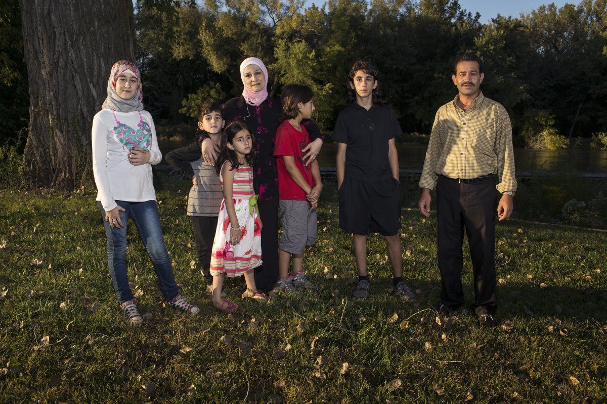 Ghazweh and Abdul Fattah at a park in Des Moines with their children, from left to right: Sedra, Mutaz, Hala, Haidar and Nazeer. Image by Danny Wilcox Frazier—VII for TIME. Des Moines, IA, 2016.