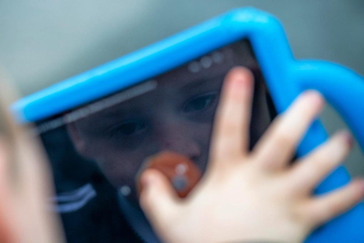 David looks up educational math videos on his iPad. David, who has autism, spends a lot of time using his iPad watching educational math videos. Image by Michael Santiago. United Kingdom, 2019.
