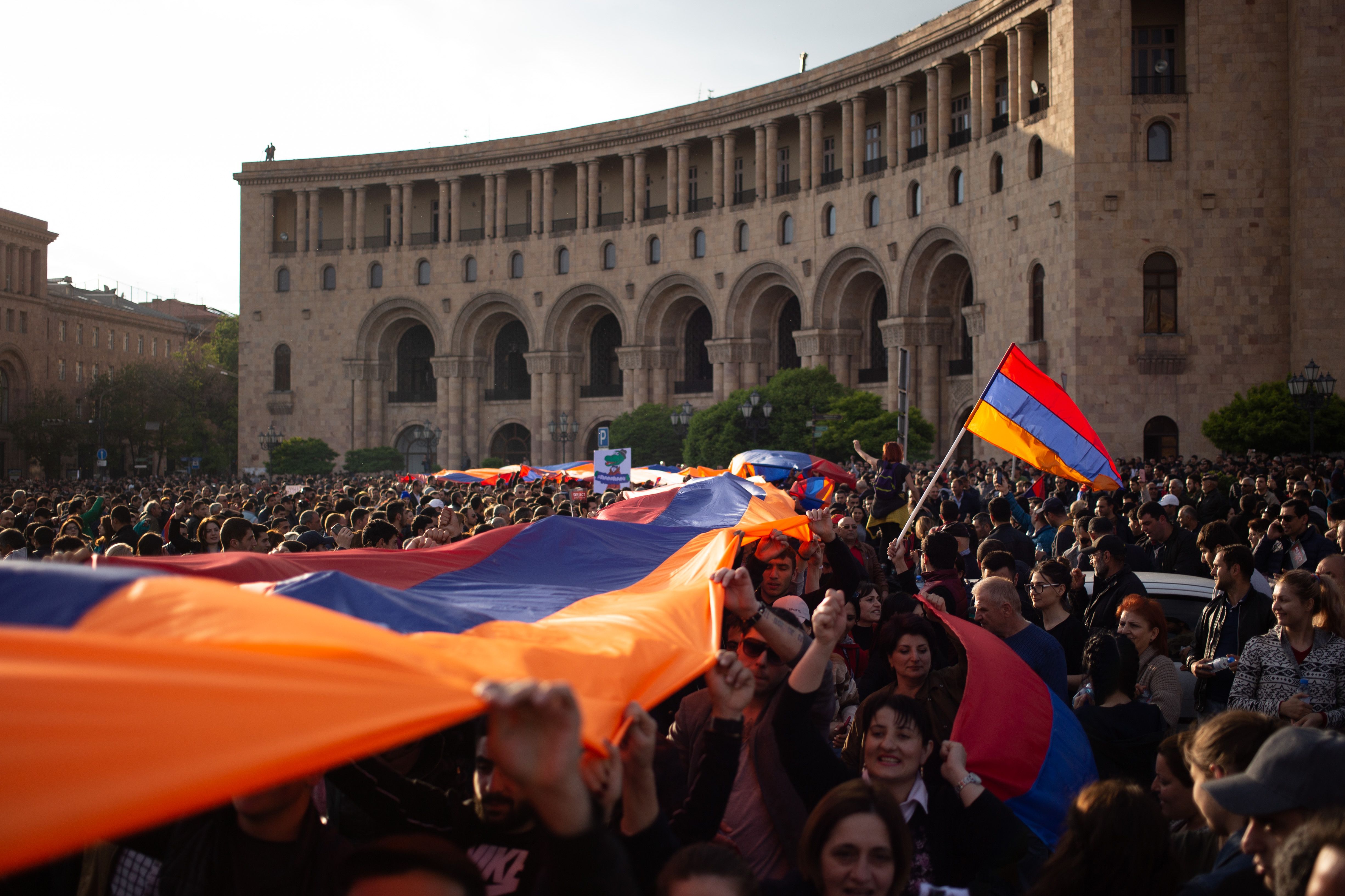 Protesters holding an Armenian flag on Yerevan's Republic Square during a rally in 2018. Image by Kacper Kawecki / Shutterstock. Armenia, 2018.