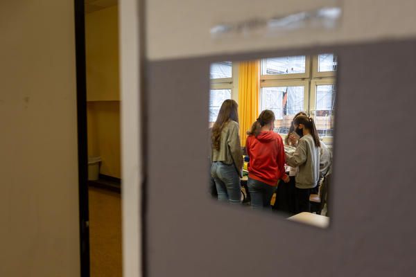 Students working on a book project at the Fritz-Karsen-Shule in Berlin are reflected in a mirror on the classroom wall. Image by Ryan Delaney. Germany, 2020.
