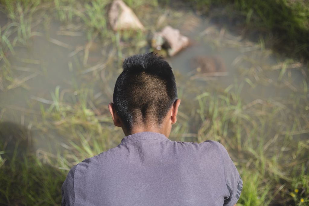 Ricardo, Winny Contreras' son, watches creatures swirl about in a small pond on a mountain overlooking their village in Mexico. Image by Ingrid Holmquist. Mexico, 2018.