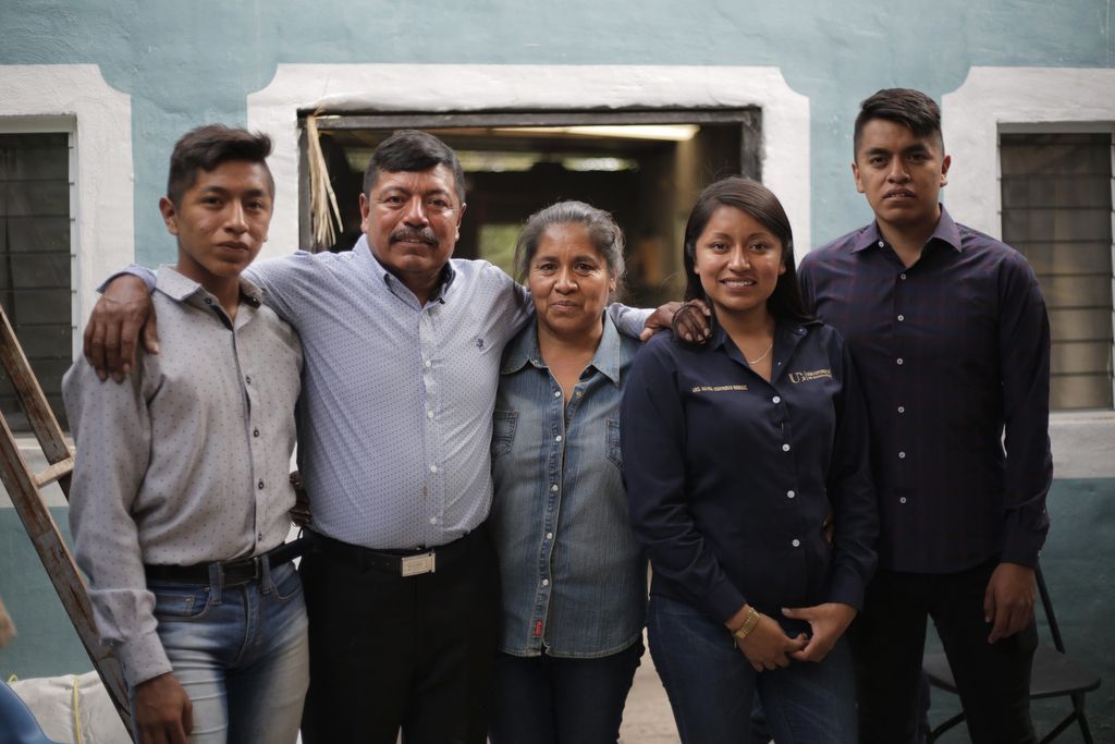 Winny Contreras with his family in Mexico at his oldest child's graduation party from architecture school. Winny spends two months in Mexico and 10 months in the United States working on a farm so he can provide for his family and fund his children's education. Image by Ingrid Holmquist. Mexico, 2018. 