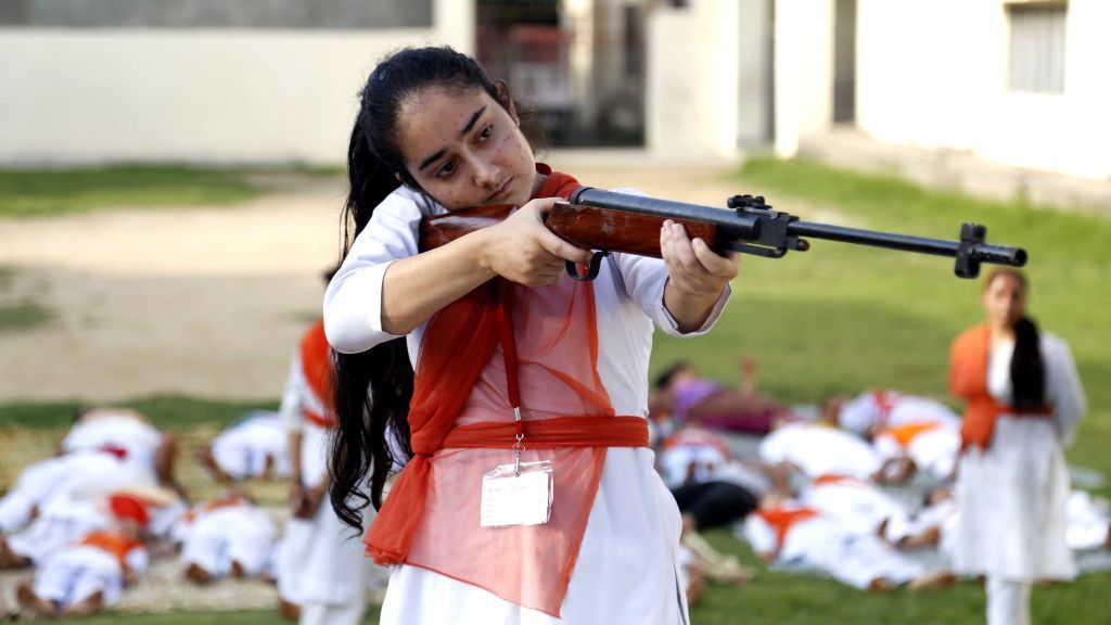 Hindu girls of the Durga Vahini, the 'saffron brigade' women's wing of the Hindu hardliner organization Vishwa Hindu Parishad (VHP), participate in a self-defense training camp, on July 7, 2017 in Jammu, India. Due to the increase in crime against women in the country, the young girls are being given training to operate sticks and guns and to develop the skills of self-defence. Image by Nitin Kanotra / Hindustan Times via Getty Images. India, 2017.