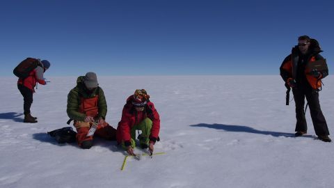 Scientists take measurements on the surface of the Greenland ice sheet. Image by Eli Kintisch.