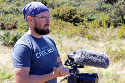 Civil Beat reporter Nathan Eagle preparing for an interview in Hanawai Natural Area Reserve while on assignment covering the endangered kiwikiu in October. Image by Dan Dennison. United States, 2019.