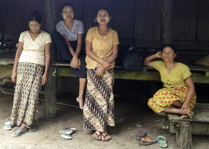 Hla Ohn May, centre, has had to take what work she can as a labourer since selling her land. She says she was never paid the amount she was promised. Image by Michael Peel. Myanmar, 2016.
