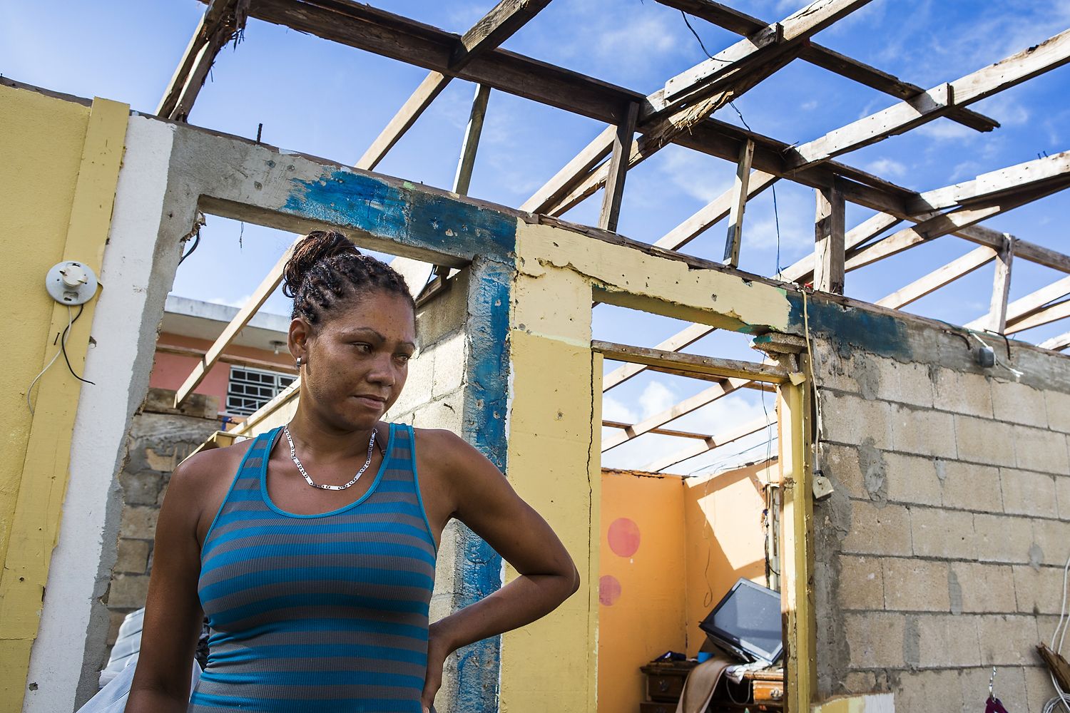 Rosalda Olma, a wife and mother to three kids, sorts through what remains of her home in Loiza. The entire home and contents were destroyed by the hurricane, and the family is living in a nearby school for the time being. “It’s hard getting used to these living conditions,” she said. “All five of us are trying to fit inside a single room.” Image by Ryan Michalesko. Puerto Rico, 2017.