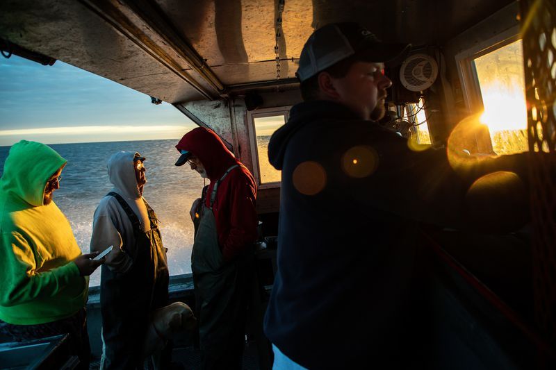 Commercial fisherman Drew Koch, right, owner of Whites Landing Fisheries in Sandusky, Ohio, pilots his fishing boat and crew in Lake Erie to pull trap nets from Lake Erie on Sept. 27, 2019. Image by Zbigniew Bzdak. United States, 2019.
