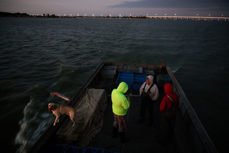 Drew Koch's commercial fishing crew waits for a sunrise before pulling the trap nets on Lake Erie near Sandusky, Ohio, on Sept. 27, 2019. Image by Zbigniew Bzdak. United States, 2019.
