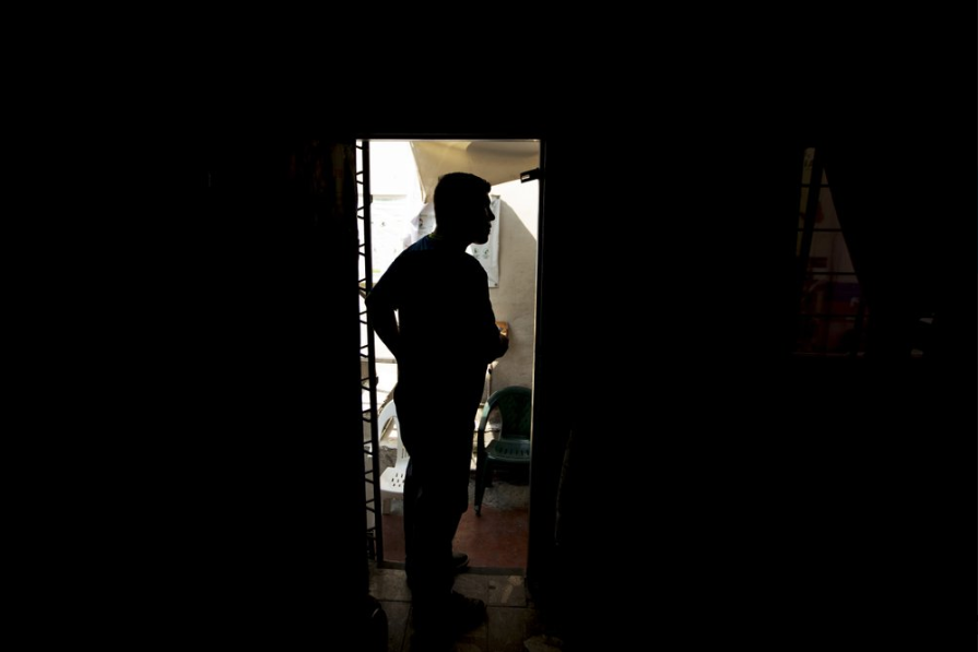 In this Sept. 18, 2019 photo, Nicaraguan migrant Yohan speaks with a new arrival to a migrant shelter where he lives with his family in Monterrey, Mexico. The 31-year-old Nicaraguan security guard trudged back across the border bridge from Laredo, Texas, in July with his wife and two children in tow, clutching a plastic case full of documents including one with a court date to return and make their asylum claim to a U.S. immigration judge two months later. Image by Fernando Llano. Mexico, 2019.