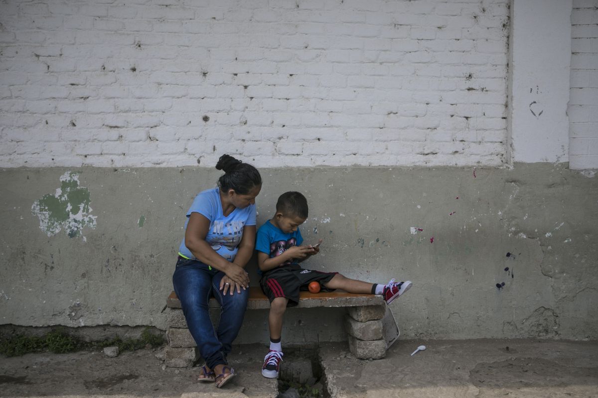 Honduran migrant Sandra and her son, Angel, have been staying at the Todo por Ellos migrant shelter in Tapachula since June. She left behind her husband, a gang member, out of fear that her children would inherit the gang life or be killed. Image by Jose Cabezas. Mexico, 2018. 