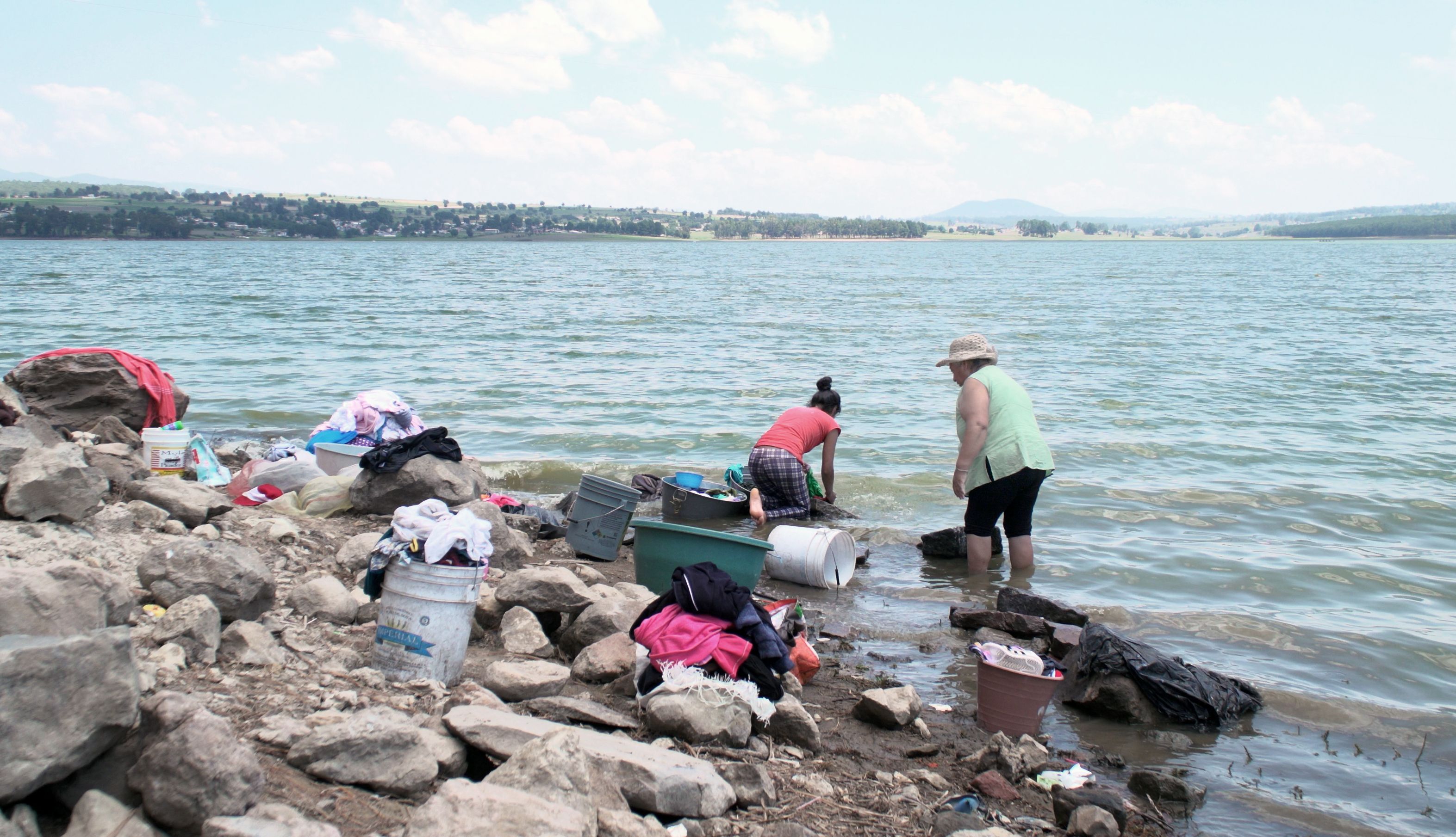 Women clean laundry in Villa Victoria, which is one of the ten dams within the Cutzamala System sub-basins. Image by Meg Vatterott. Mexico, 2018. 